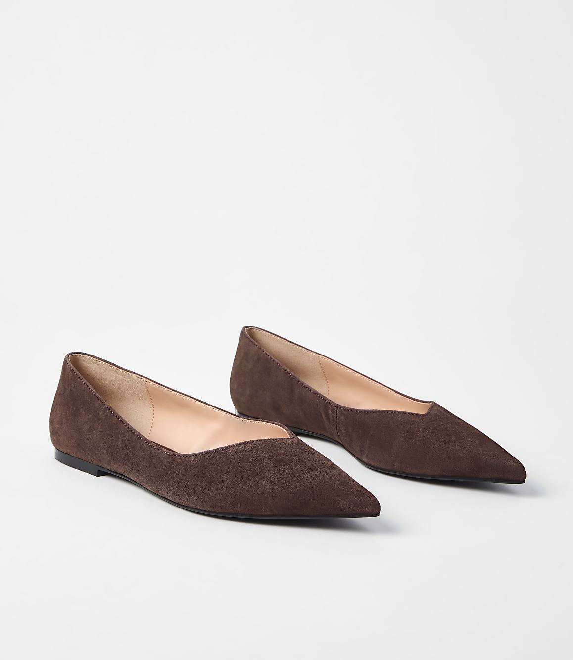 A pair of brown suede pointed-toe flats rests on a plain white background.