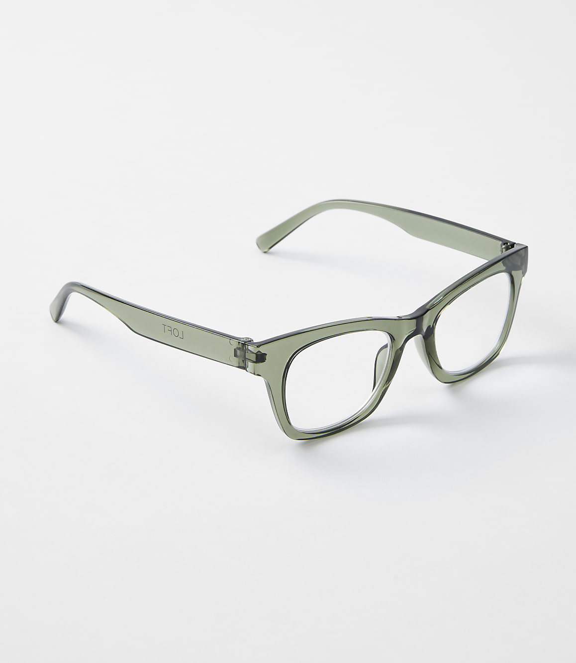 A pair of translucent green glasses rests on a plain white background.