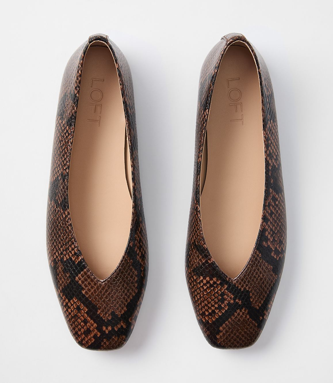 A pair of brown snakeskin print ballet flats with a V-shaped opening are laid flat against a plain white background.