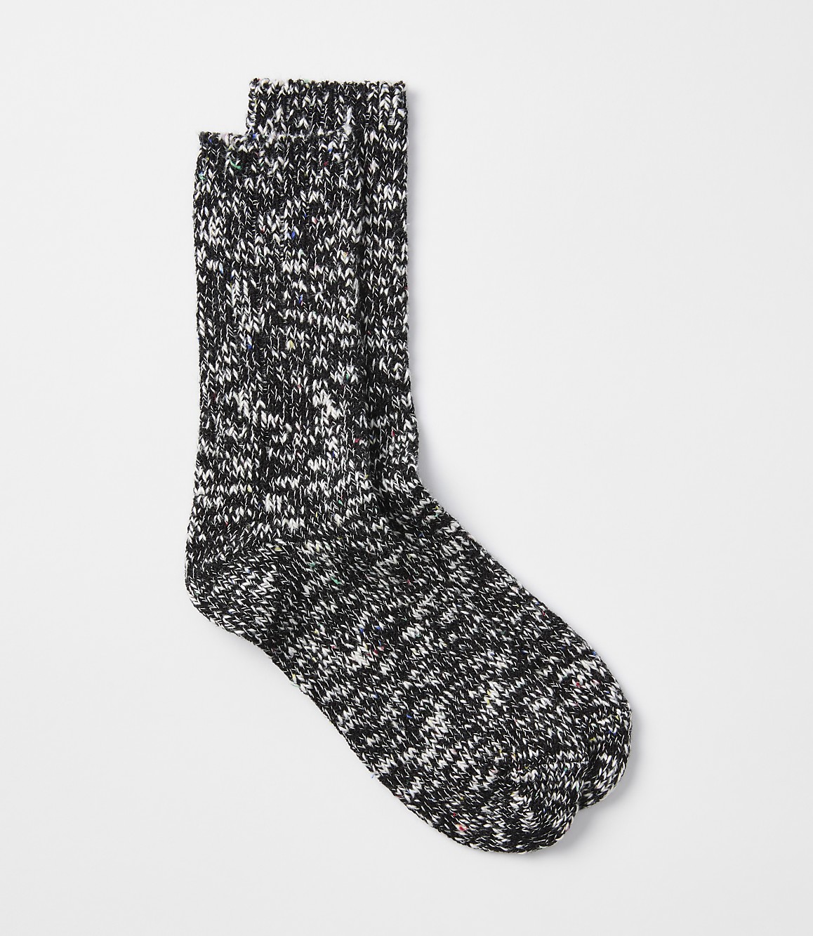 A pair of speckled black and white socks rests on a plain white background.
