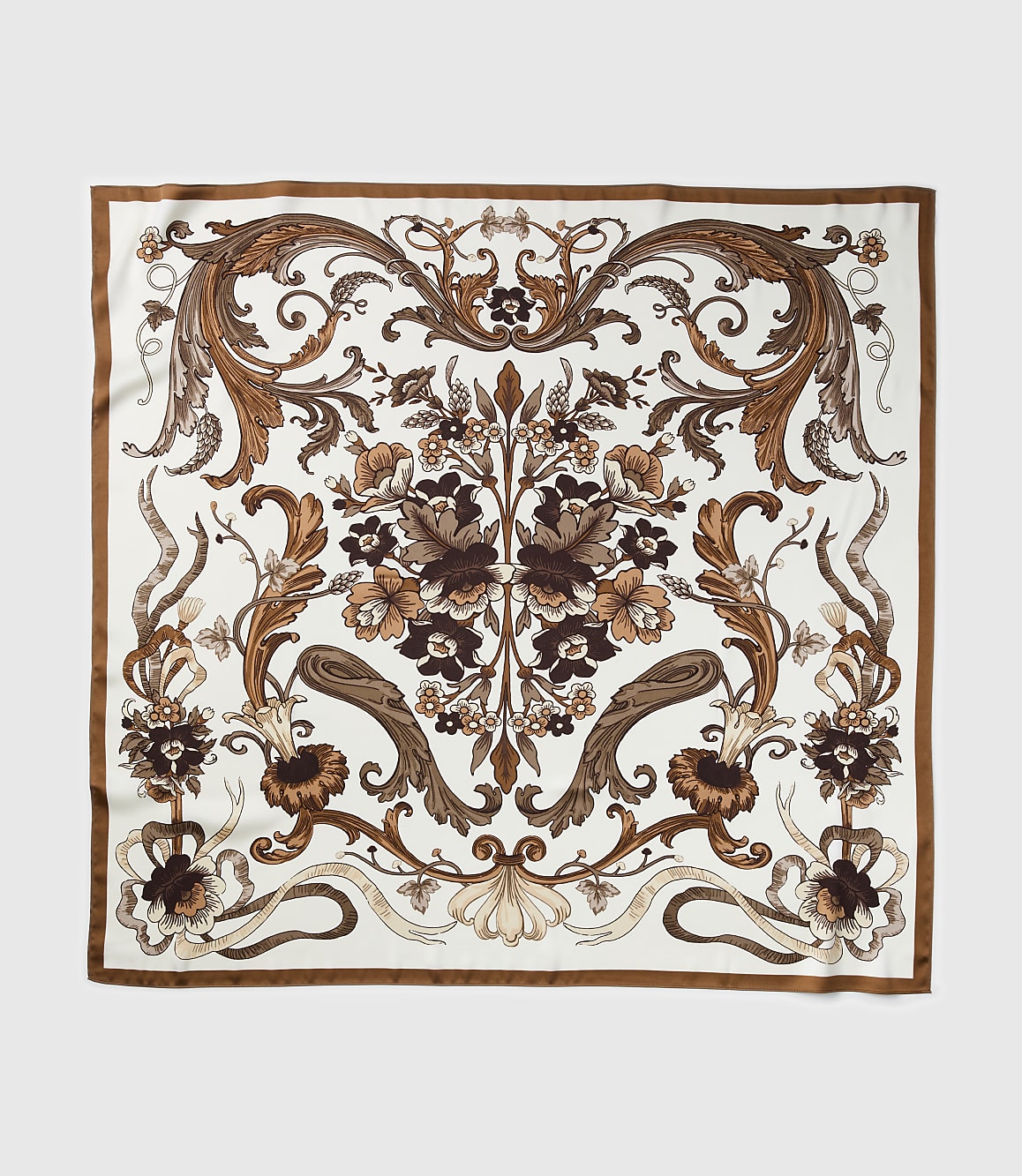 A square silk scarf with an ornate brown floral pattern on a white background is displayed against a plain gray backdrop.