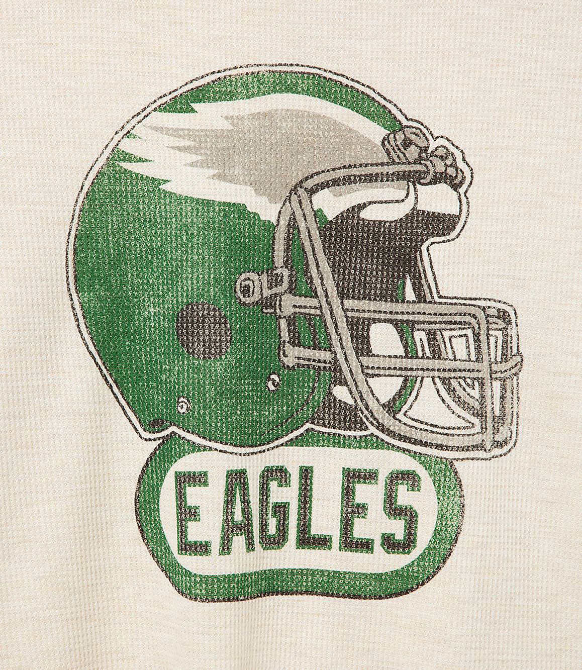 A distressed graphic of an Eagles helmet with the word "Eagles" below it is printed on a cream-colored, textured fabric.