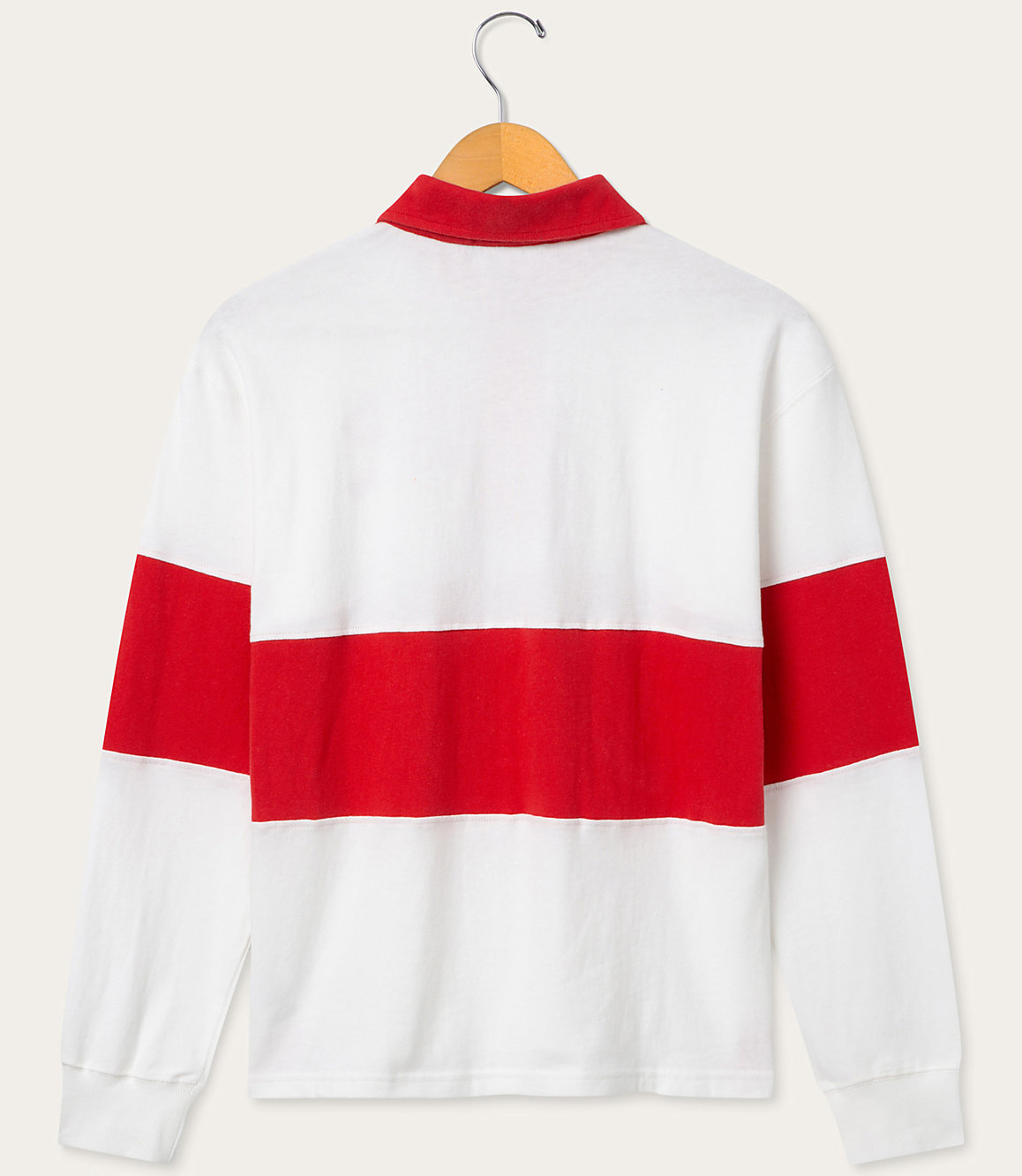 A white and red striped long-sleeved rugby shirt hangs on a wooden hanger against a plain white background.