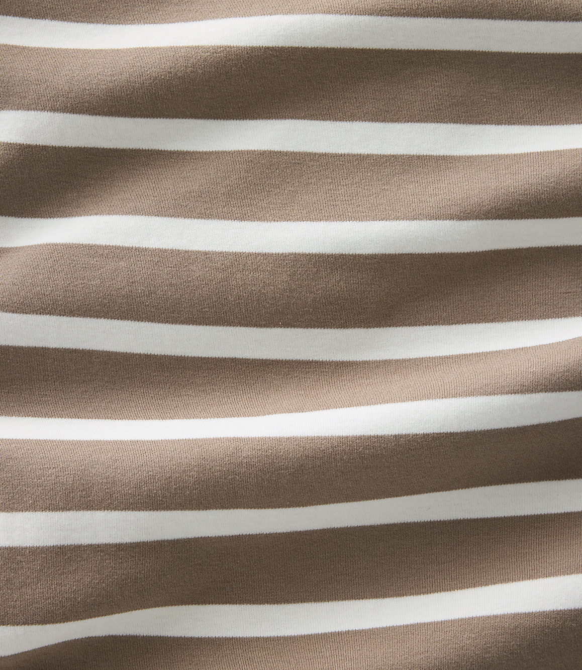 A close-up view of brown and white horizontal stripes on fabric fills the frame, with subtle wrinkles creating a textured background.