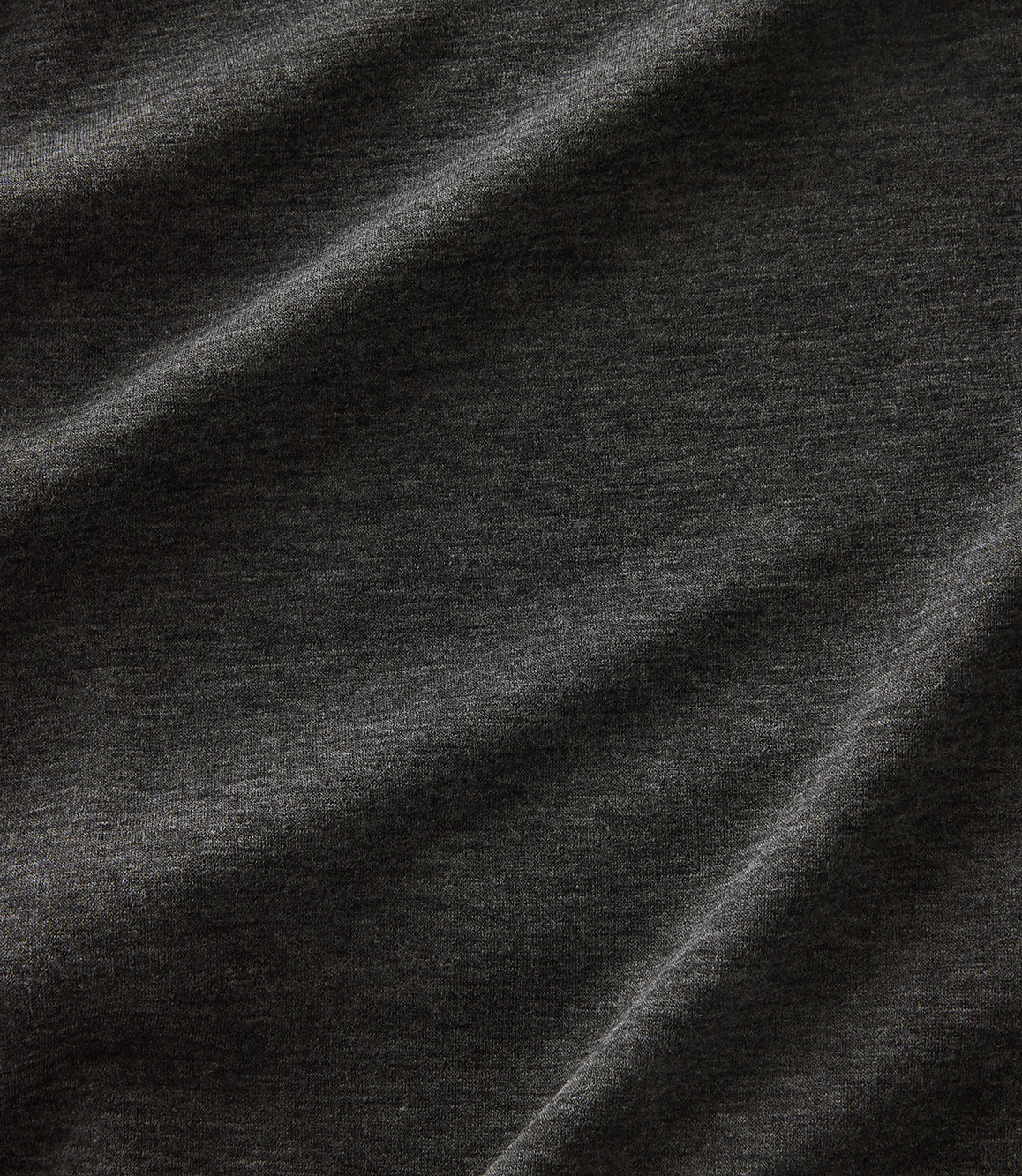 Dark gray fabric with soft folds and subtle texture fills the frame.