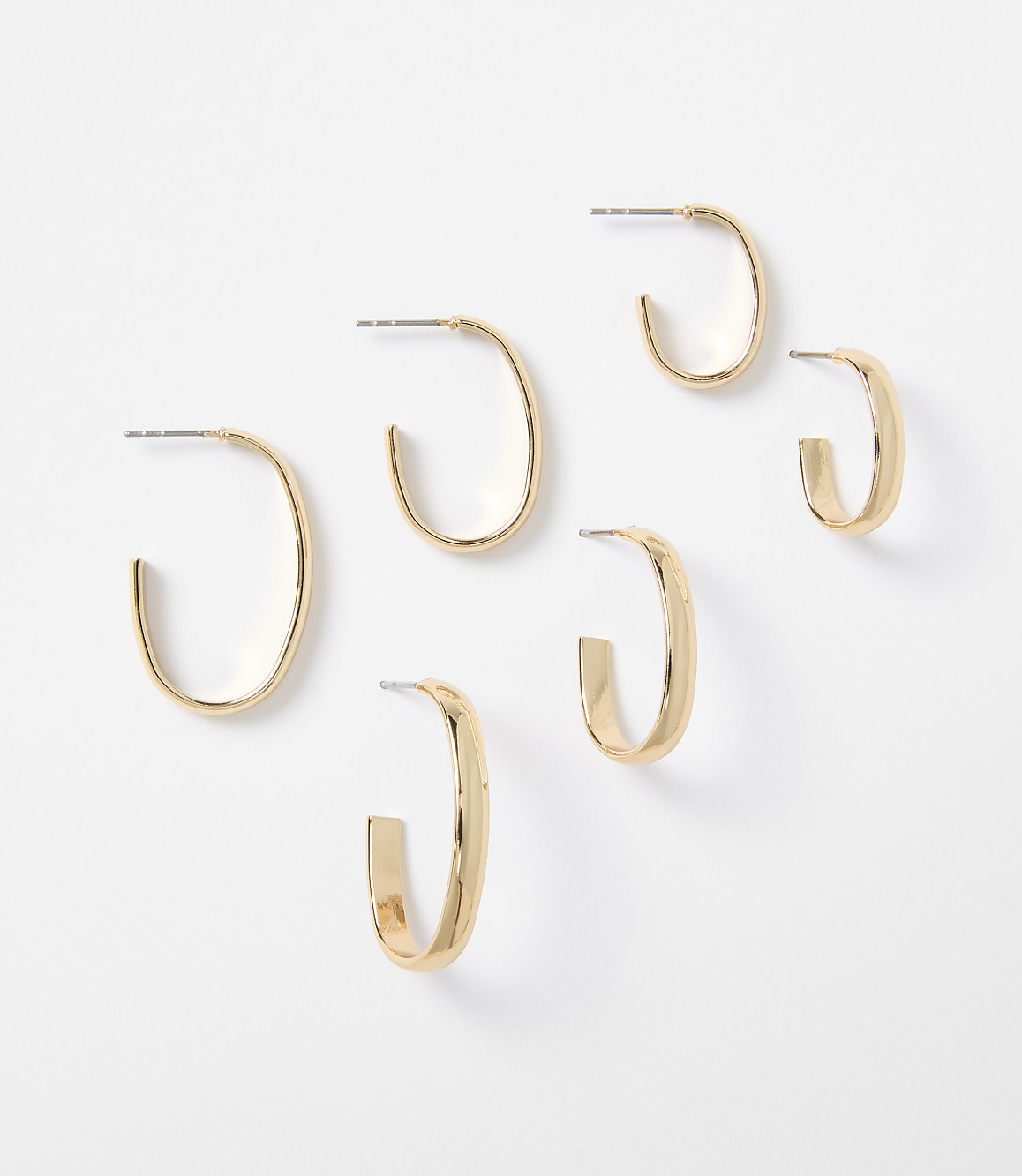 Six gold hoop earrings of varying sizes are arranged on a plain white background.