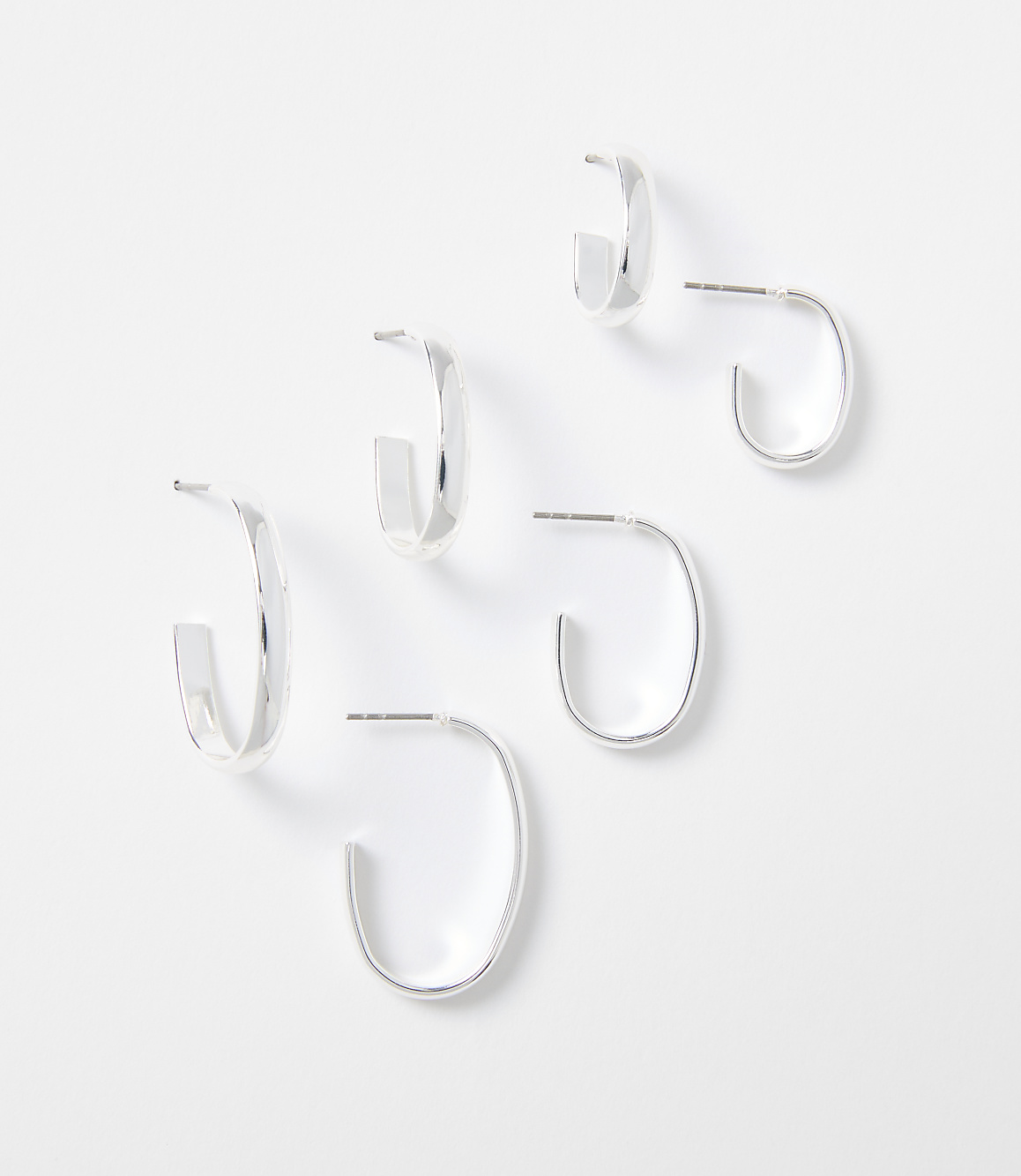 Three pairs of silver hoop earrings are arranged on a plain white background.