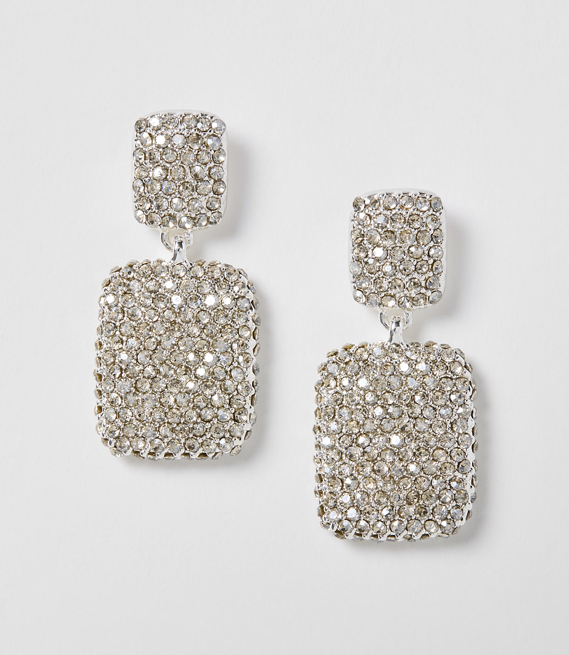 A pair of dazzling, rectangular, rhinestone-encrusted drop earrings hang against a plain white background.