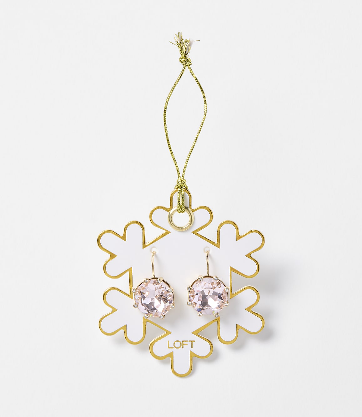 A pair of pink crystal earrings hangs from a gold string attached to a white snowflake ornament with gold trim, set against a plain white background.