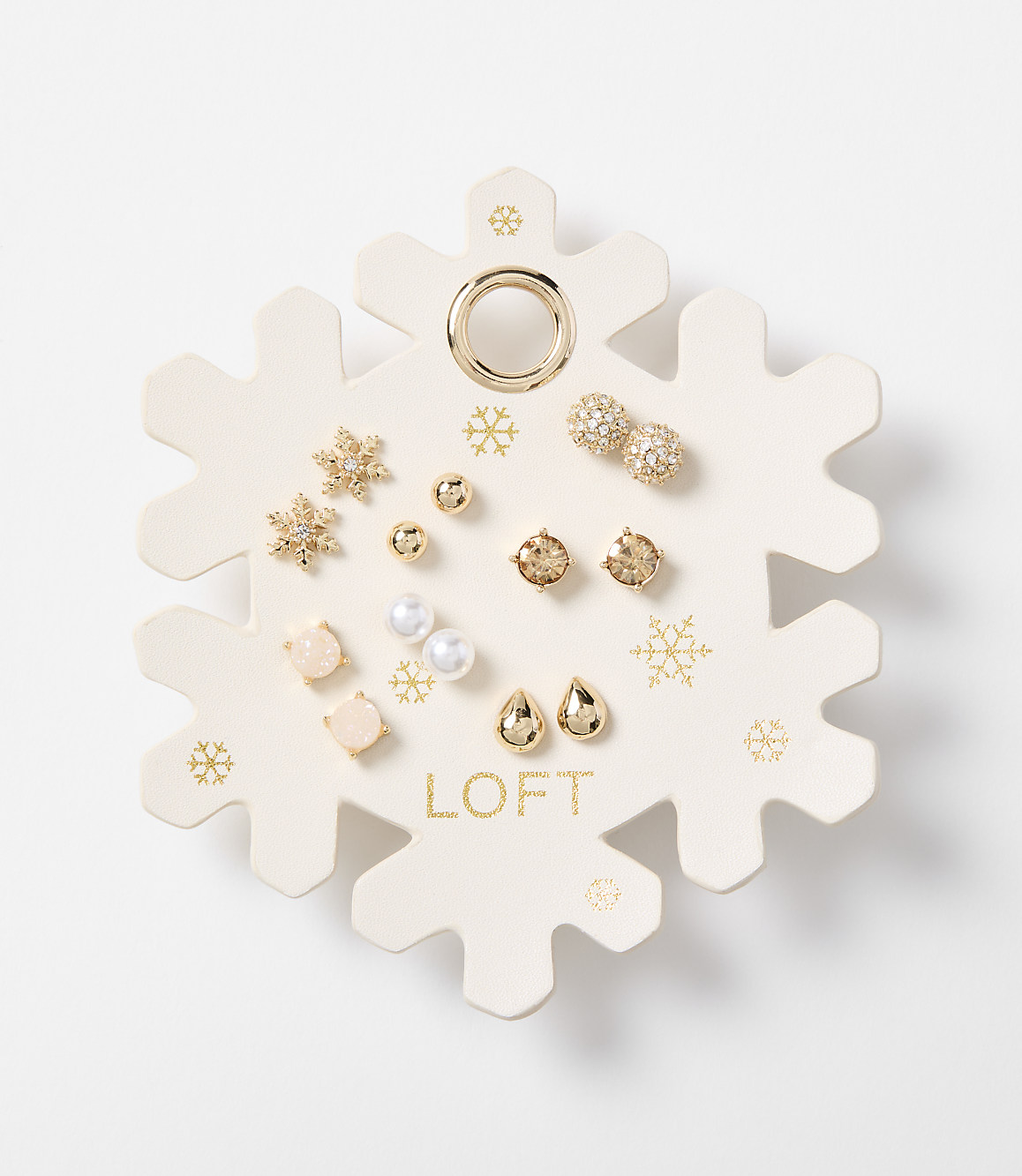 A snowflake-shaped card displays an assortment of small, decorative earrings in the foreground, set against a plain white background.