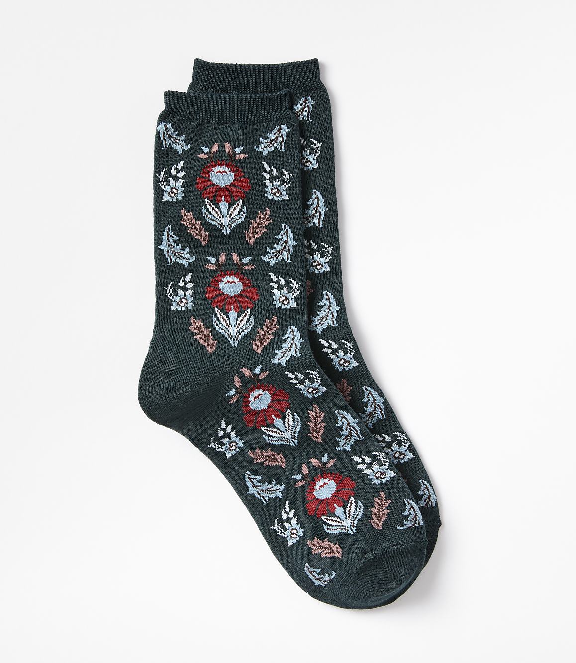 A pair of dark green socks with a floral pattern are laid out against a plain white background.