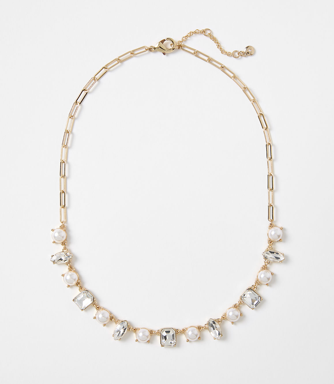 A gold chain necklace with alternating pearls and clear rectangular gems is displayed against a plain white background.