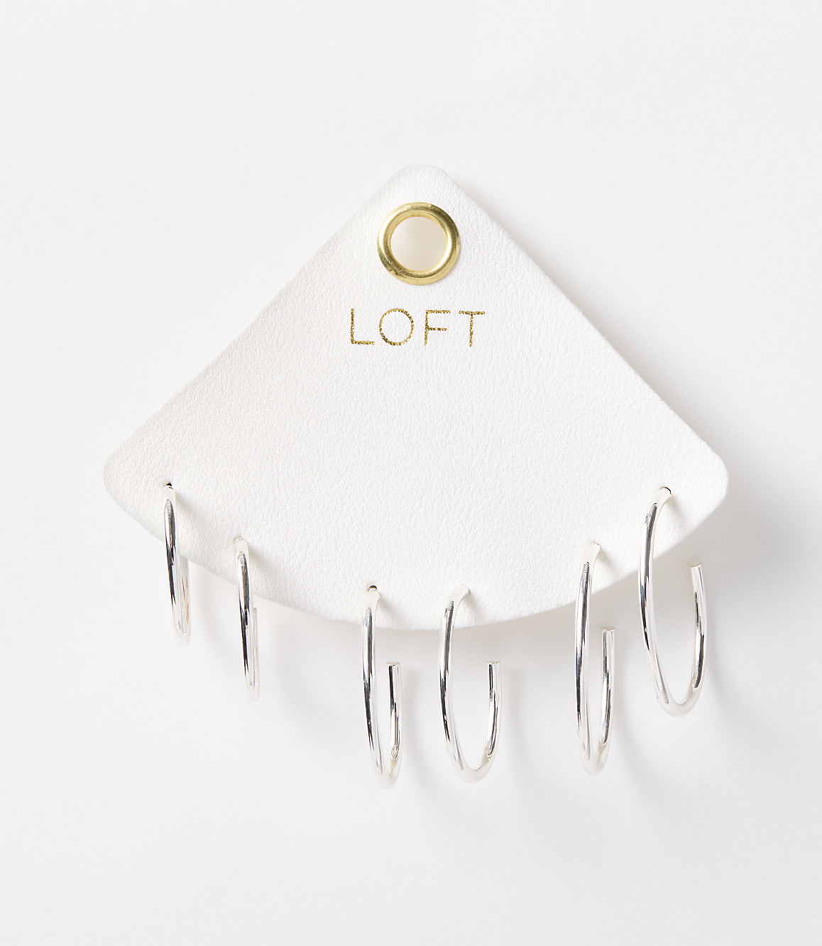 A set of six silver hoop earrings are displayed on a white triangular card with the "LOFT" logo, against a plain white background.