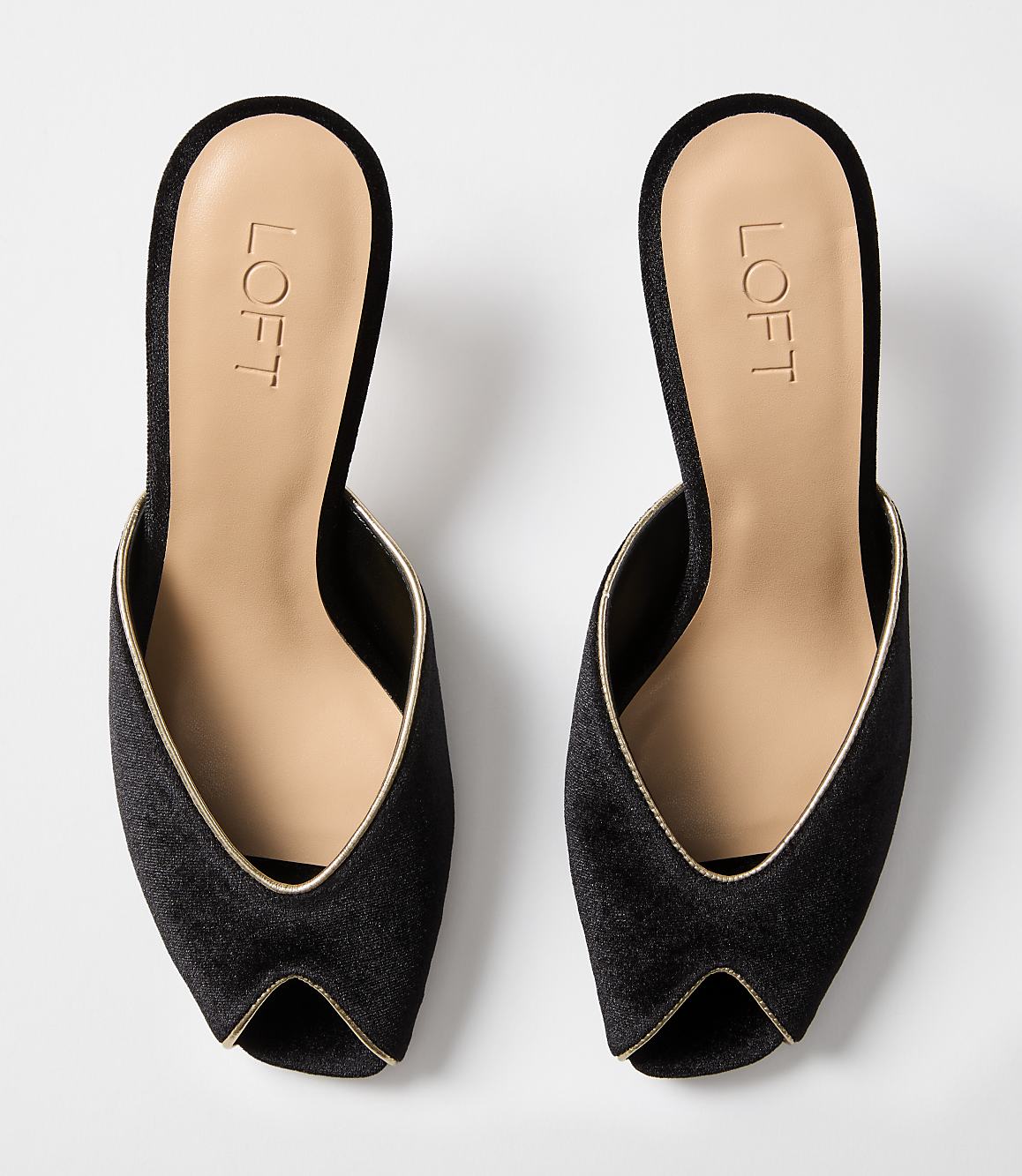 A pair of black velvet mules with gold trim are displayed against a plain white background.