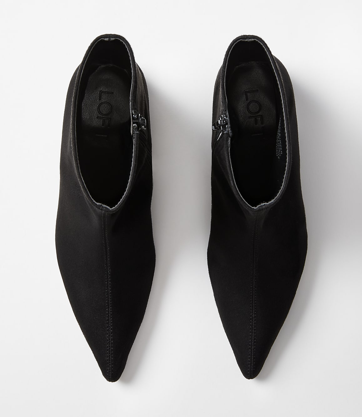 A pair of black pointed-toe ankle boots with zippers are displayed against a plain white background.