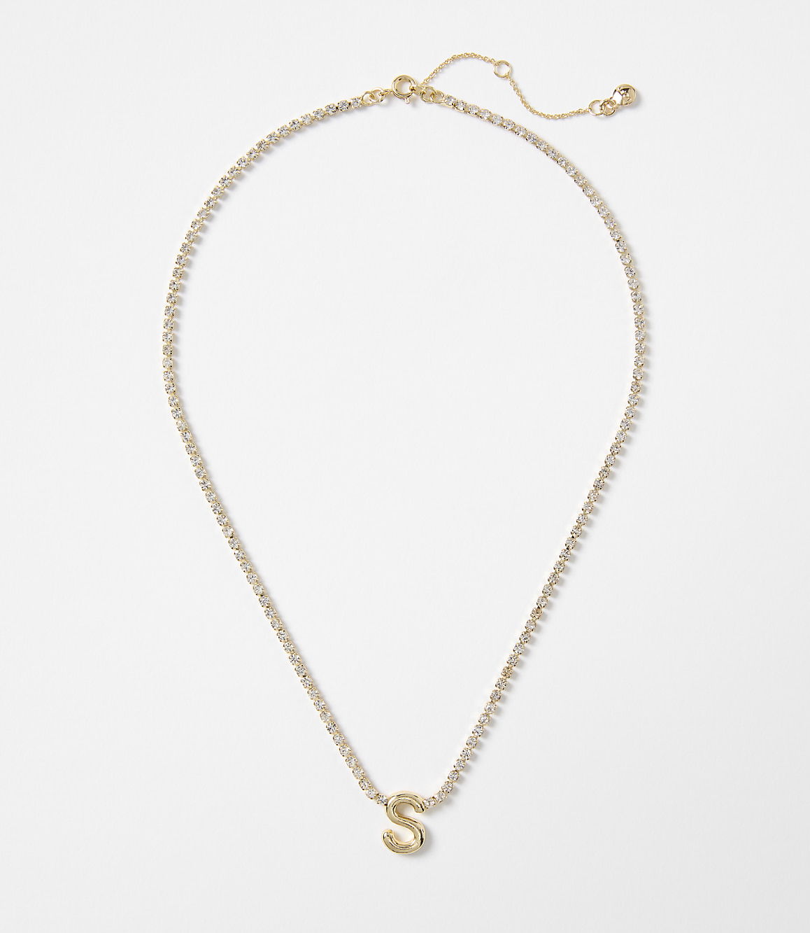 A gold letter "S" pendant hangs from a delicate, sparkling chain against a plain white background.