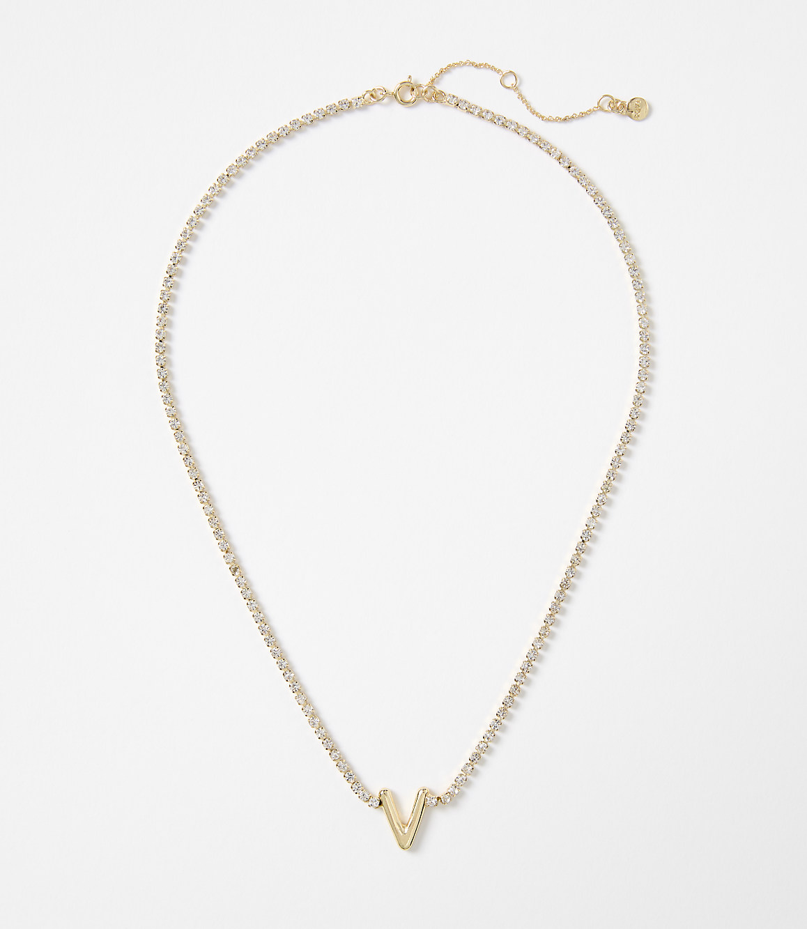A gold necklace with a "V" pendant rests on a plain white background.