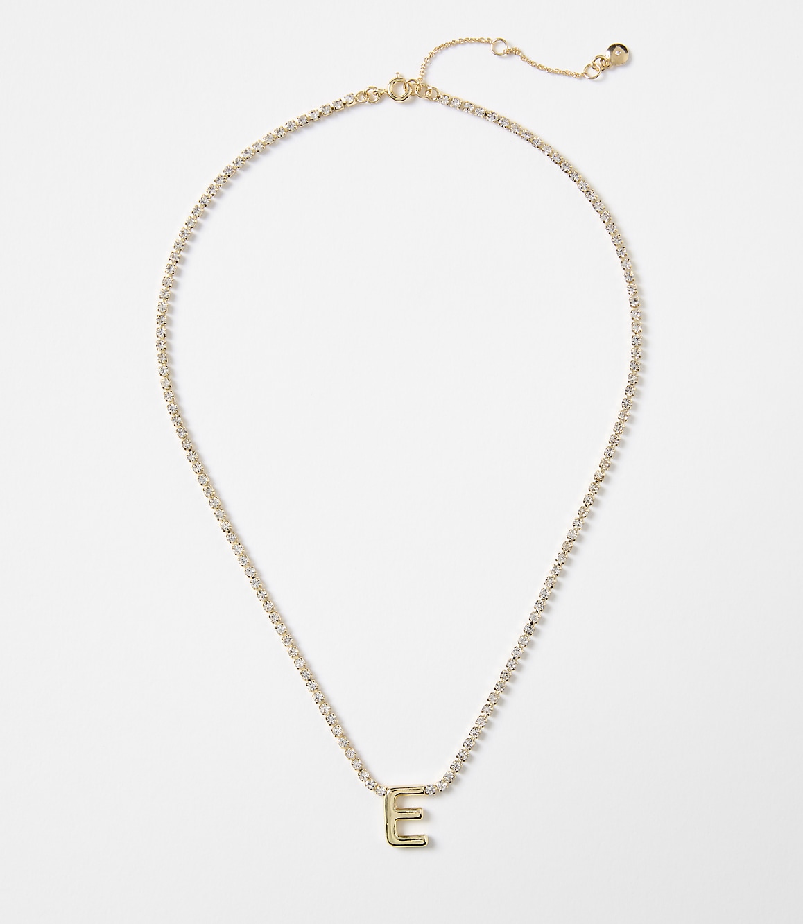 A gold letter "E" pendant on a delicate, diamond-studded chain rests against a plain white background.
