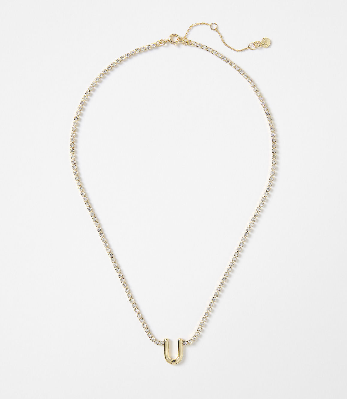 A gold letter "U" pendant hangs from a delicate, diamond-encrusted chain against a plain white background.