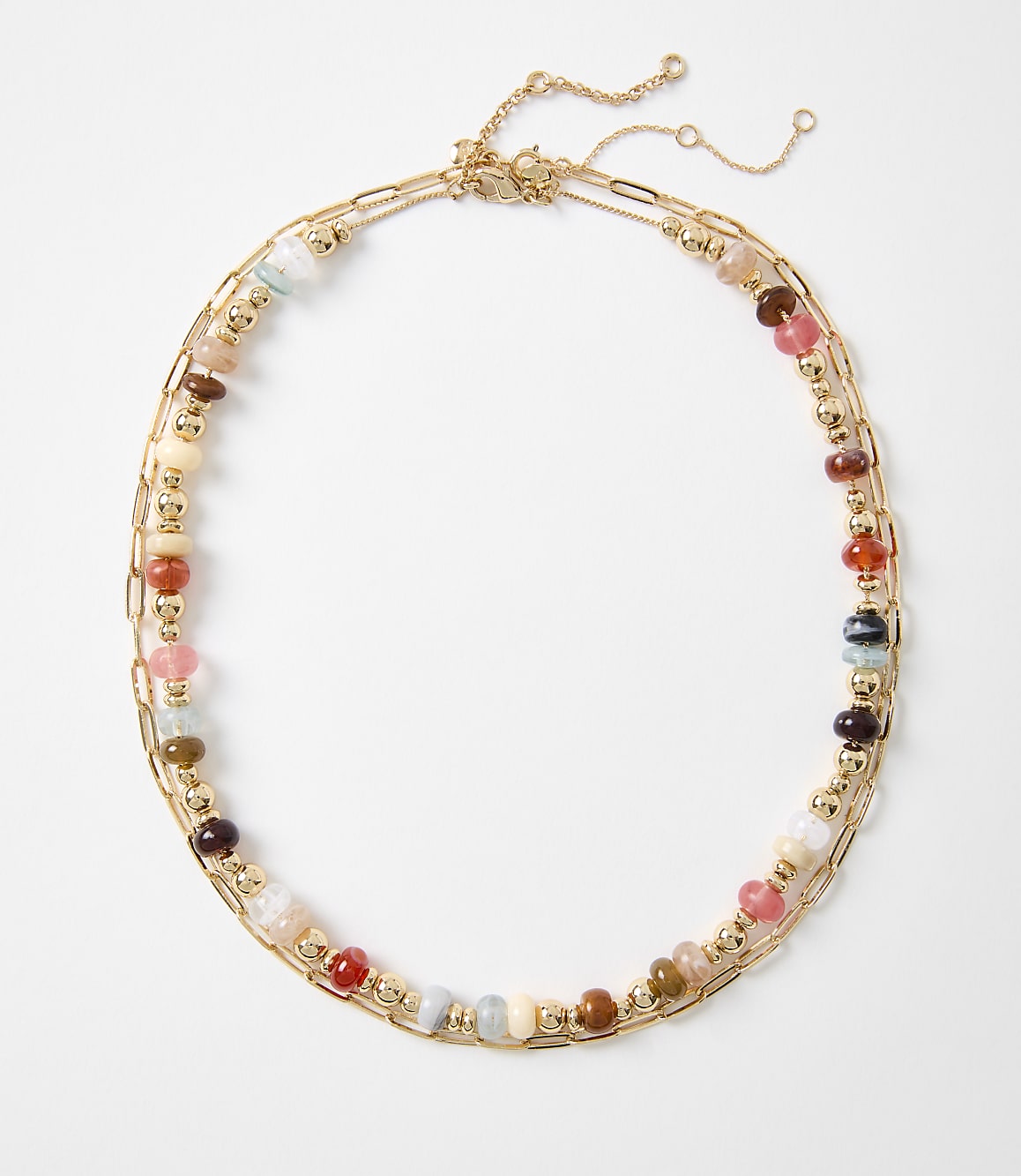 A colorful beaded necklace with gold chain accents lies on a plain white background.