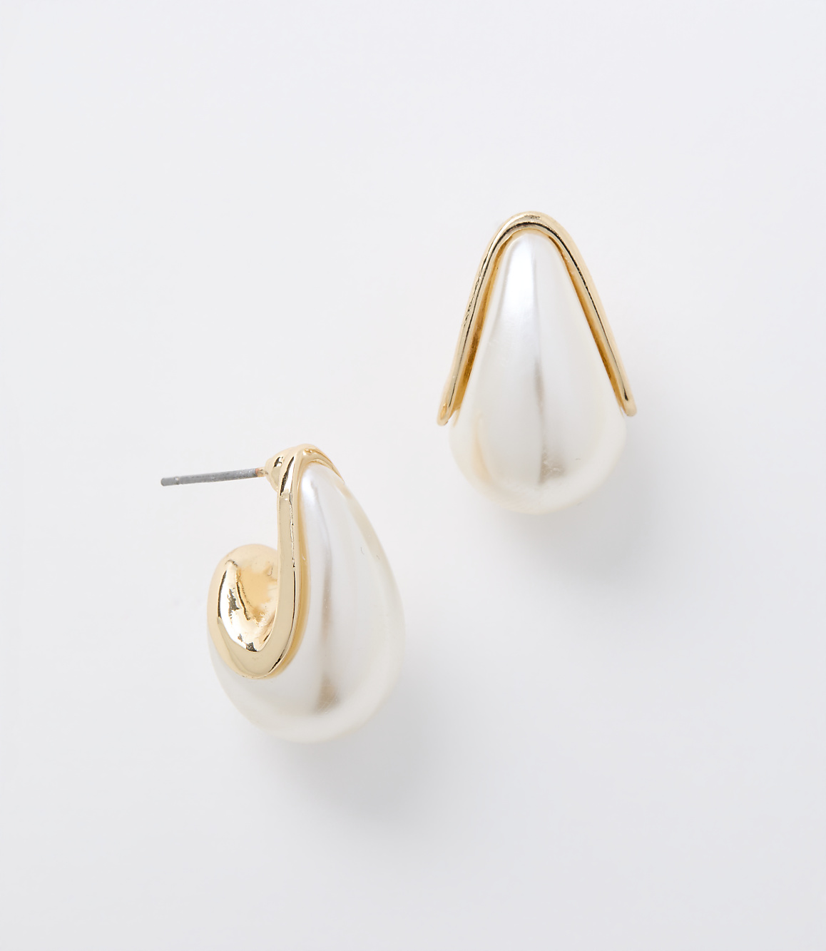 A pair of pearl and gold teardrop earrings rests on a plain white background.