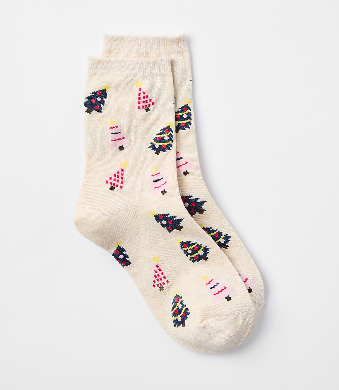 A pair of cream-colored socks with a pattern of festive Christmas trees are laid out against a plain white background.