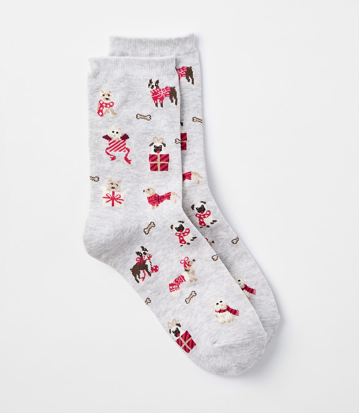A pair of light gray socks with a pattern of festive dogs wearing sweaters and scarves, along with dog bones and presents, are laid out against a plain white background.