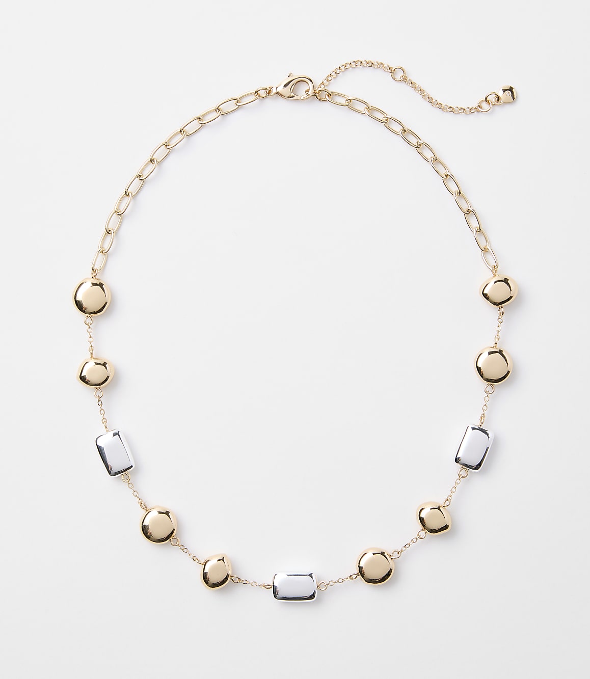 A gold chain necklace with alternating gold discs and clear rectangular beads is laid out on a plain white background.