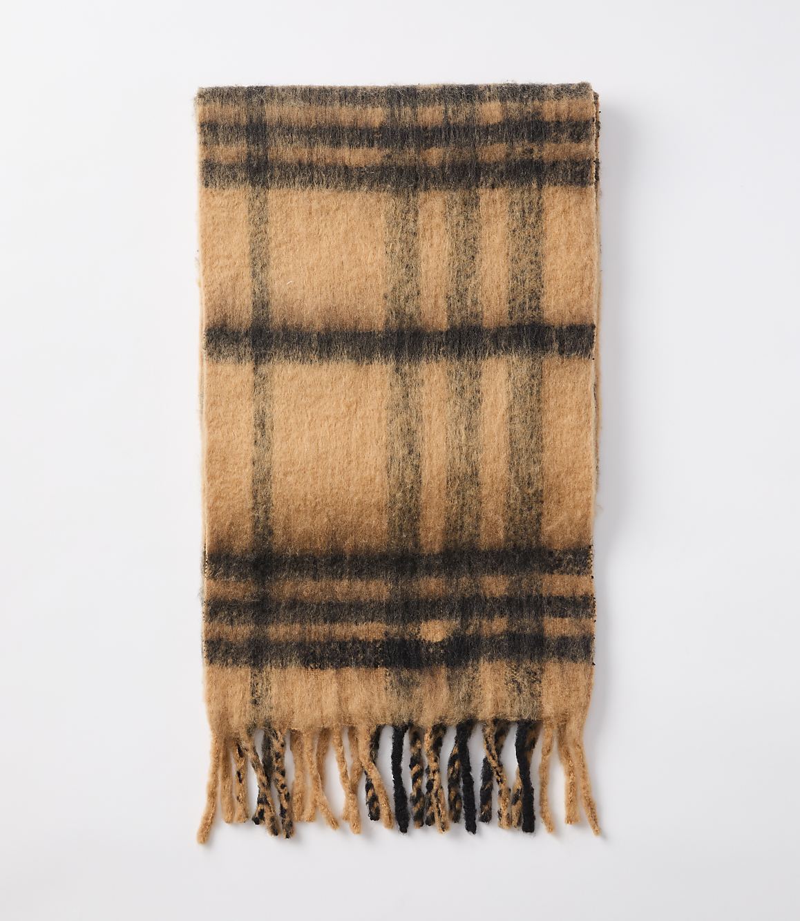 A fuzzy, plaid scarf with fringed ends lies flat against a plain white background.