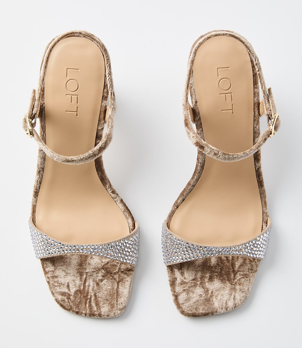 A pair of beige velvet sandals with rhinestone embellishments on the toe strap and ankle strap are displayed against a plain white background.