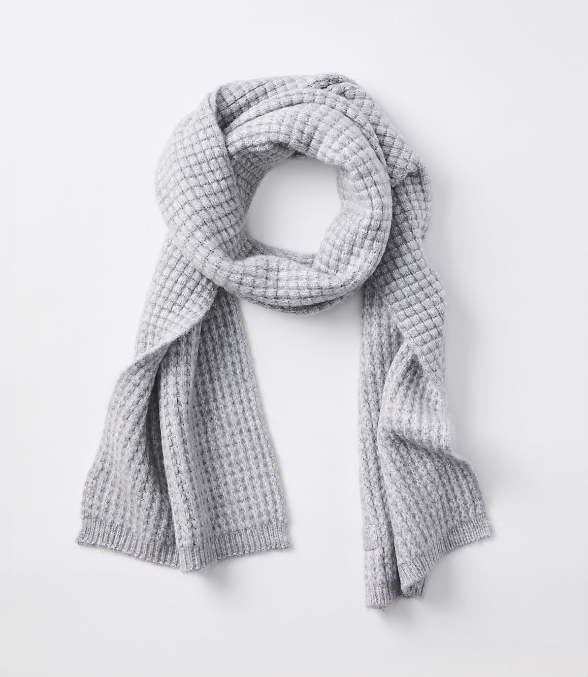 A light gray waffle-knit scarf is draped over a plain white background.