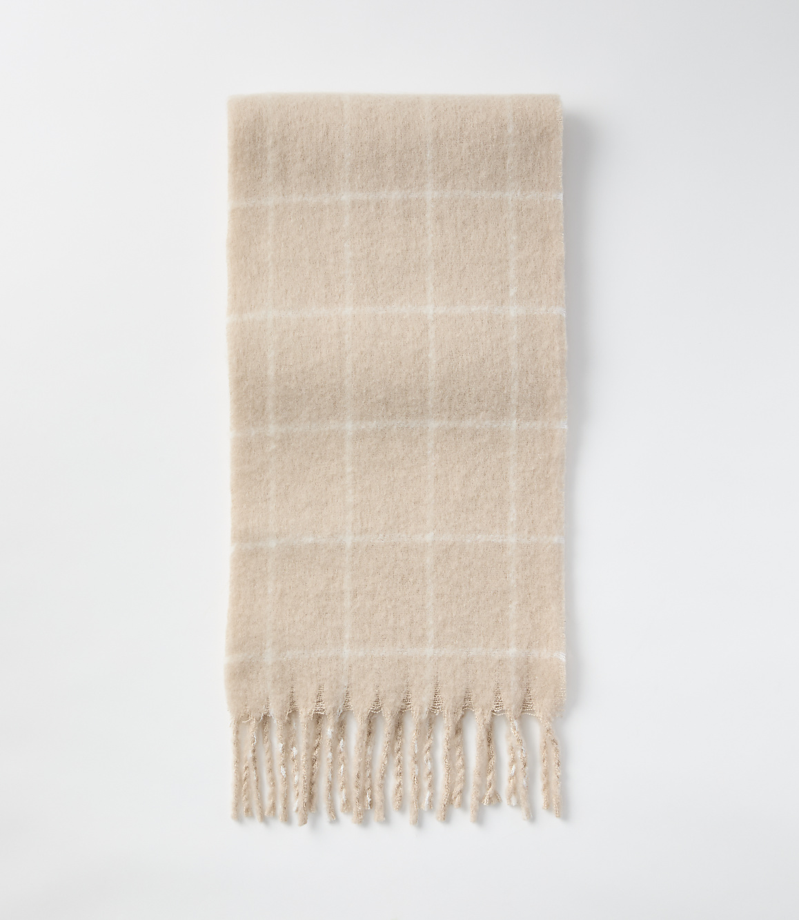 A fuzzy, beige plaid scarf with fringe lies on a plain white background.
