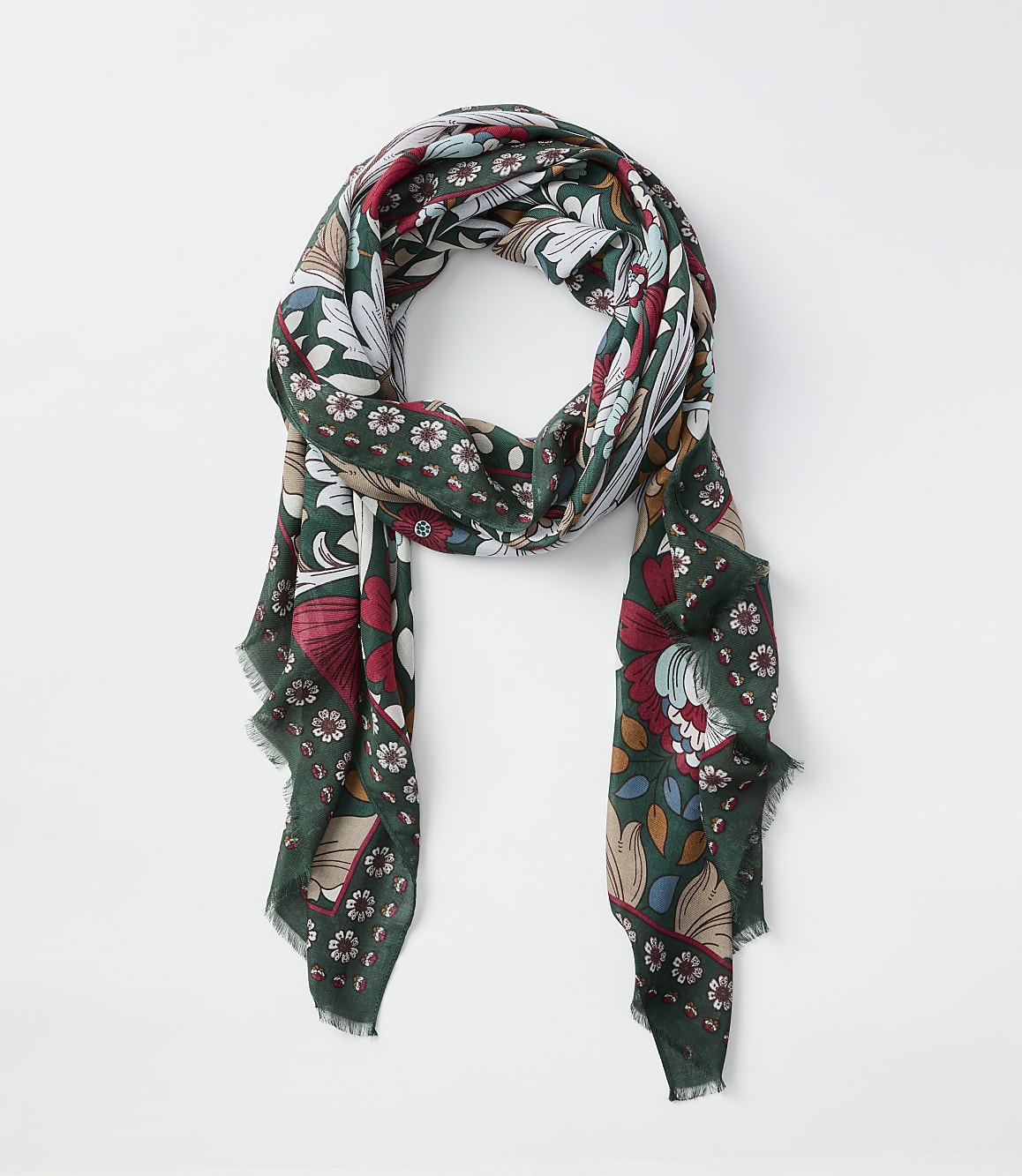 A green scarf with a floral and book pattern hangs against a plain white background.