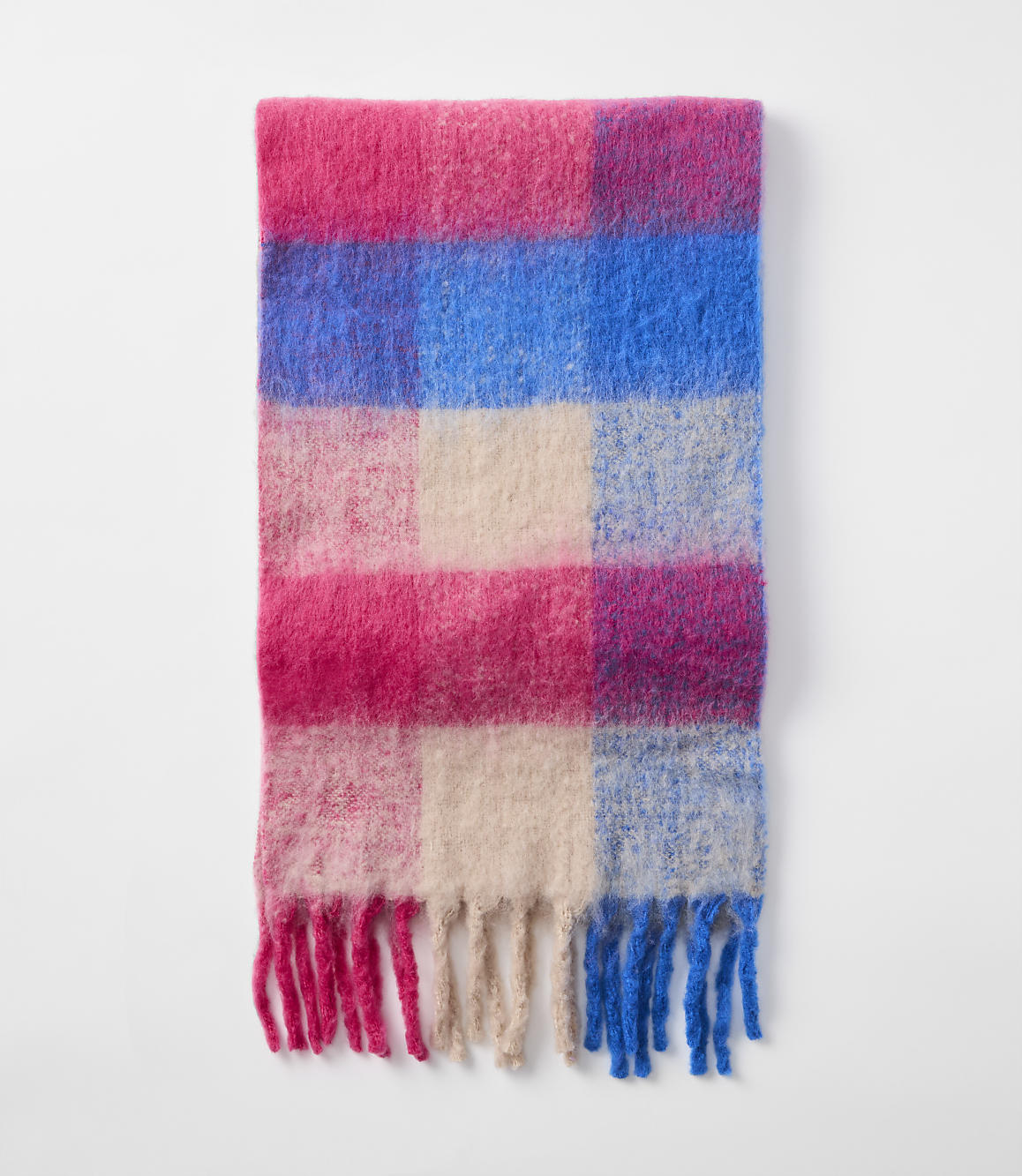 A fluffy, checkered scarf with pink, blue, and cream squares and fringed ends lies against a plain white background.
