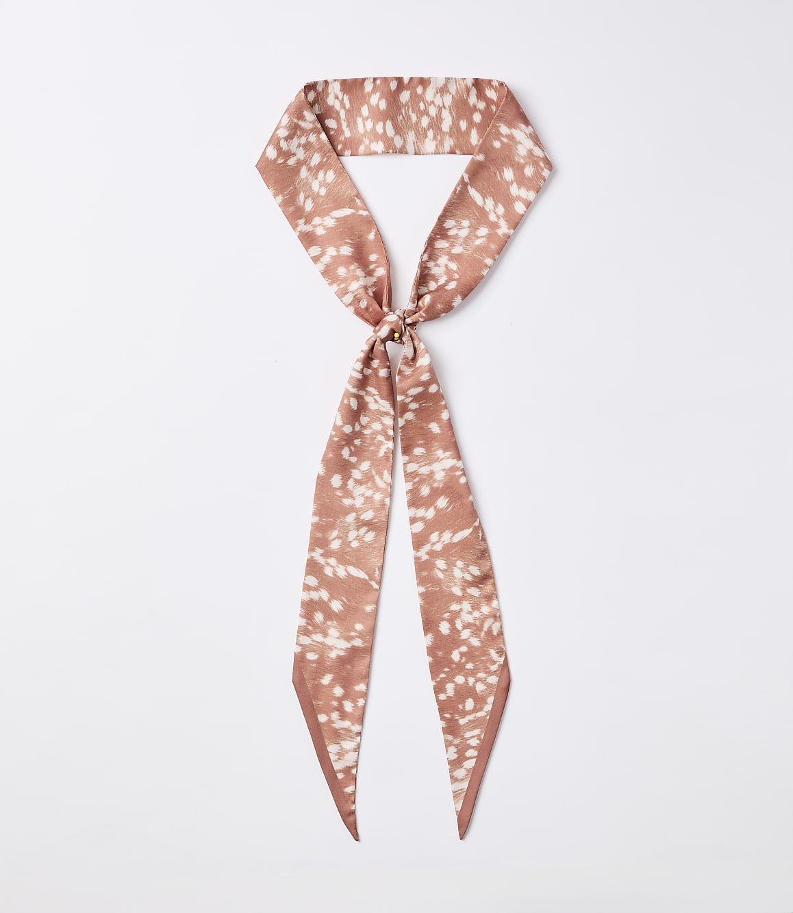 A rust-colored silky scarf with a white speckled pattern is knotted in the center, with its ends hanging down against a plain white background.