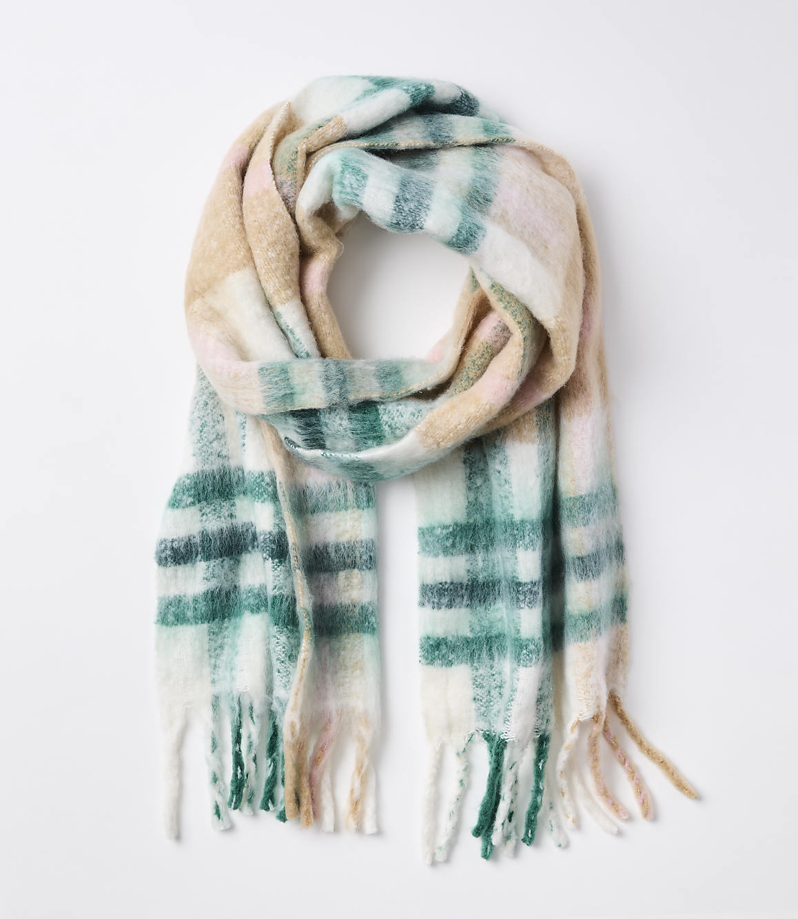A soft, plaid scarf with fringe in pastel colors is laid out against a plain white background.