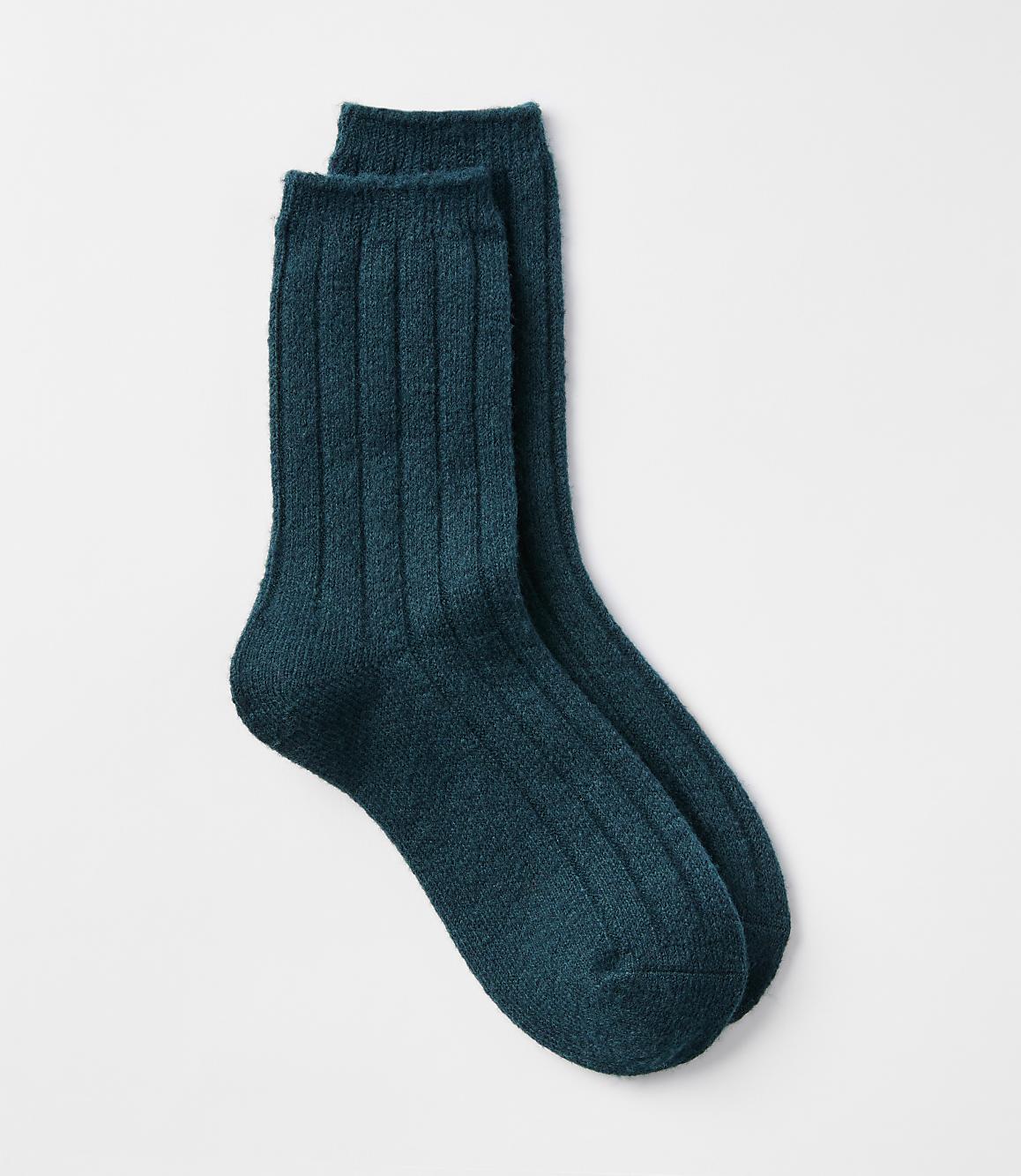 A pair of teal ribbed socks rests on a plain white background.
