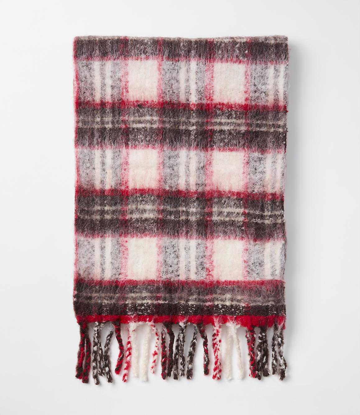 A fuzzy, red, white, and brown plaid scarf with fringe lies on a plain white background.