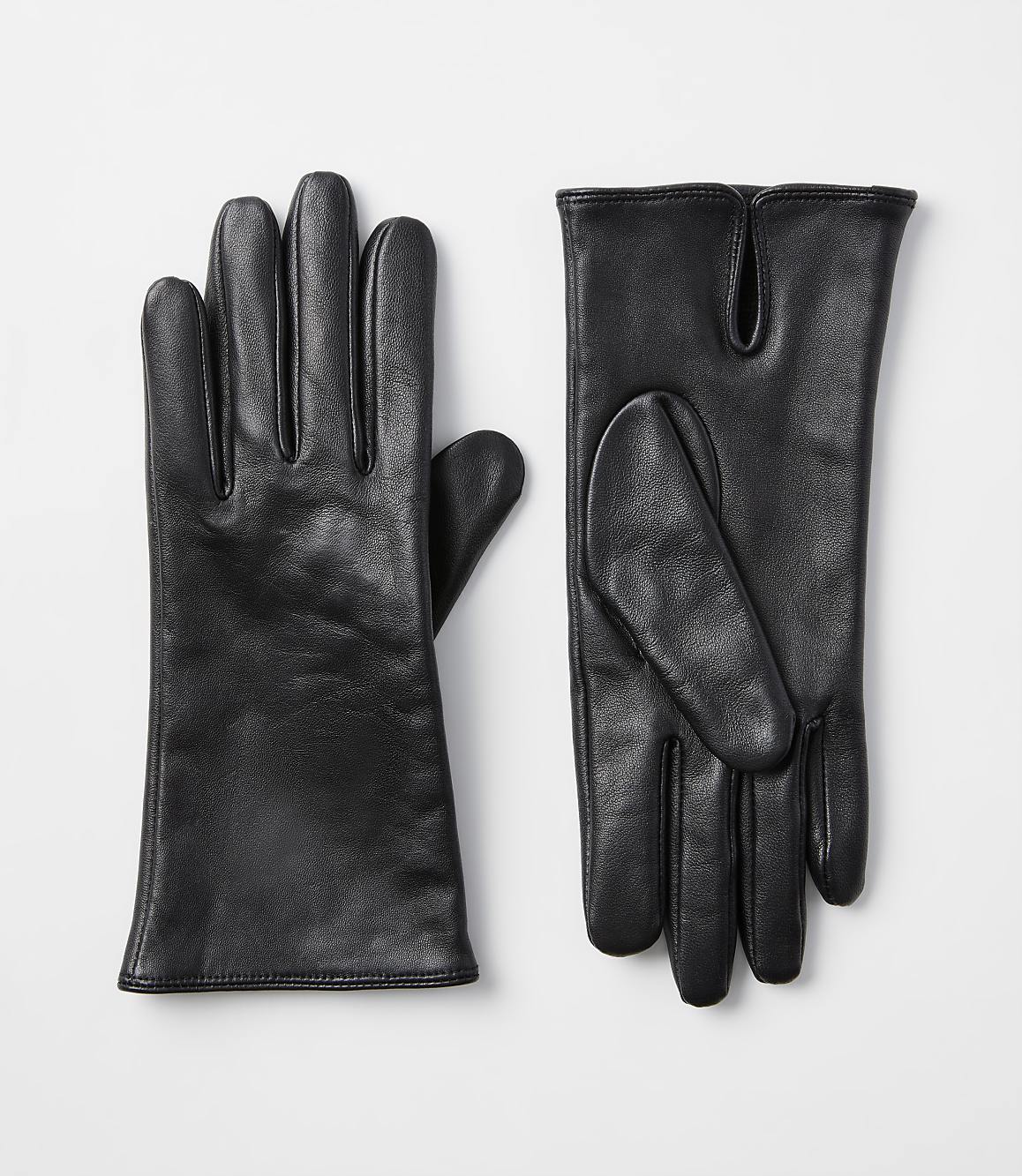 A pair of black leather gloves lies on a plain white background.