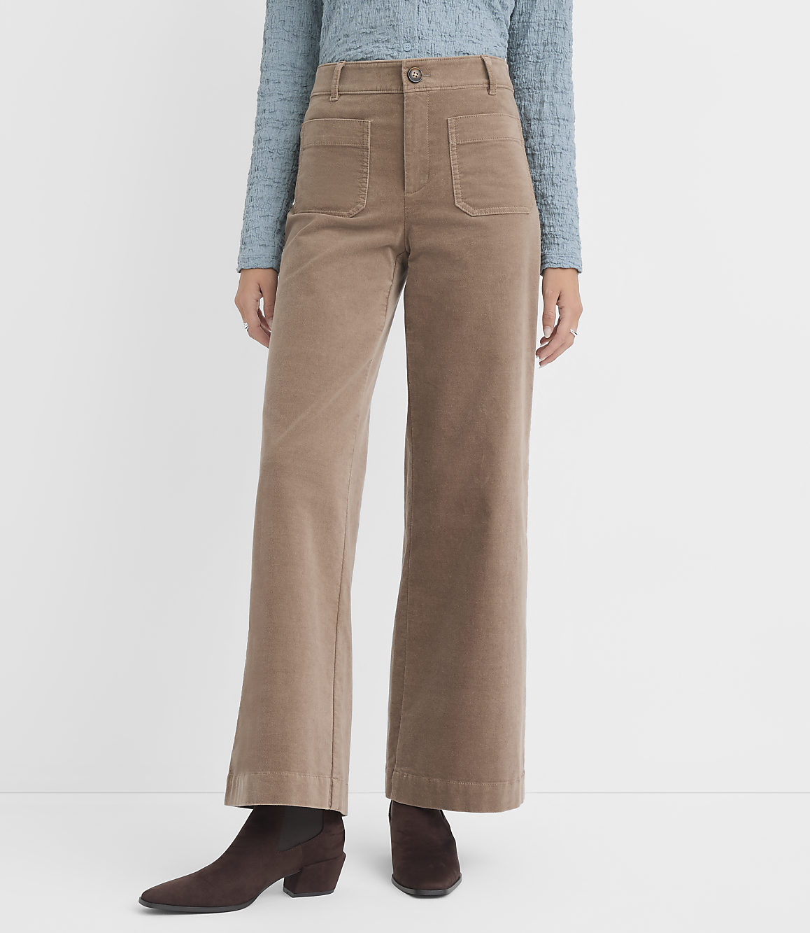 A person wearing tan corduroy wide-leg pants and brown boots stands against a plain white background.