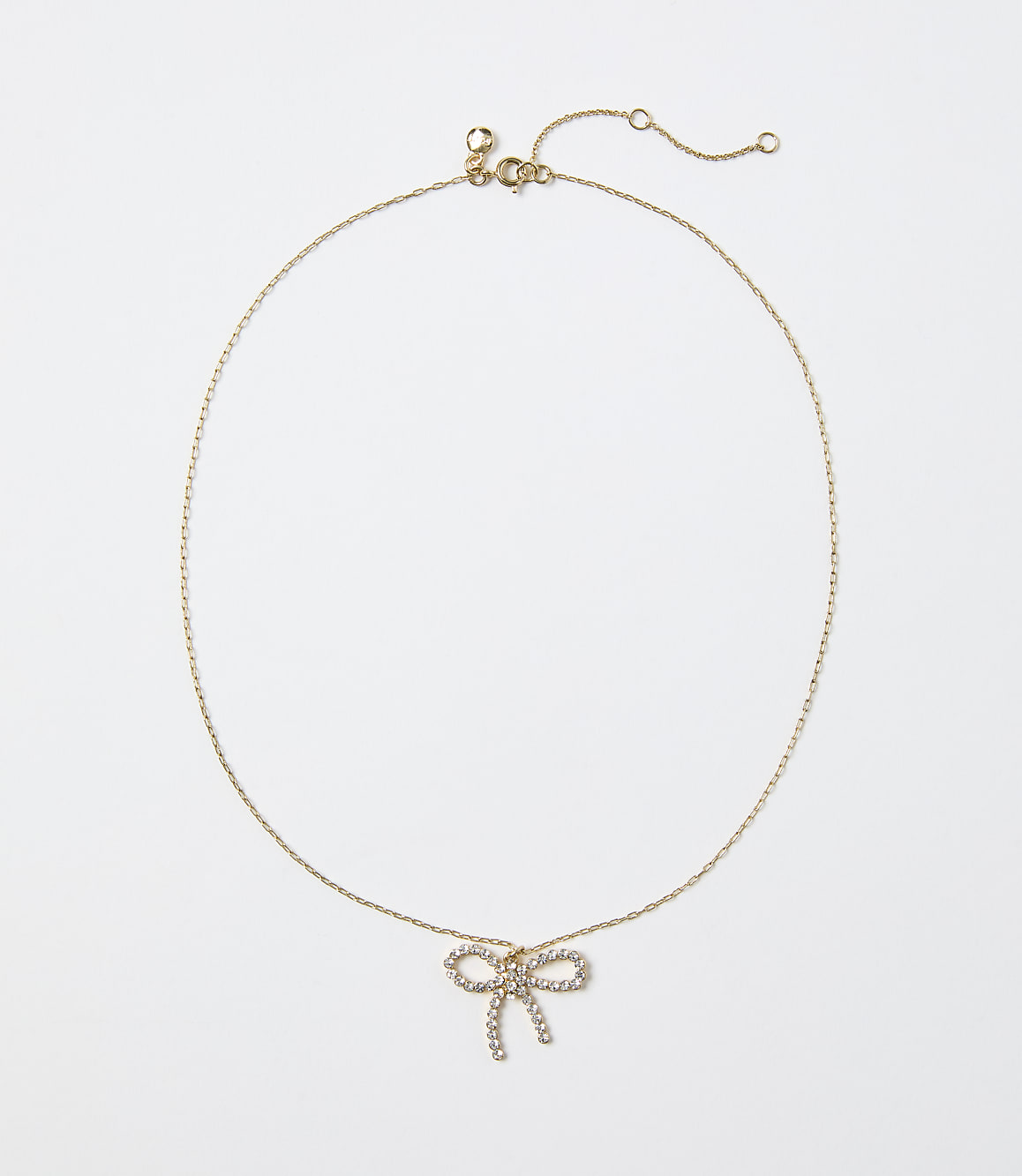 A gold chain necklace with a diamond-encrusted bow pendant rests against a plain white background.