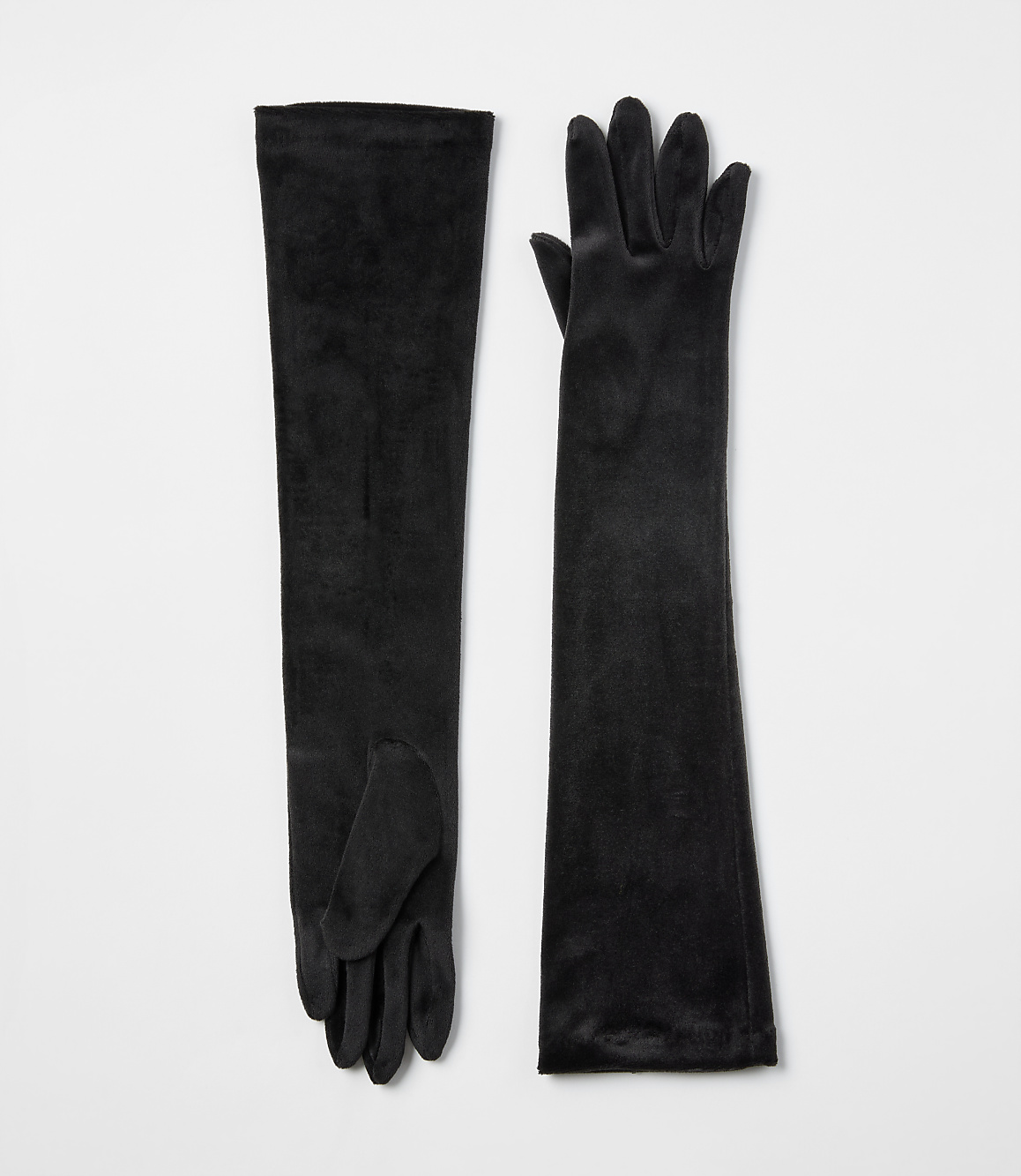 A pair of long black velvet gloves lies flat against a plain white background.