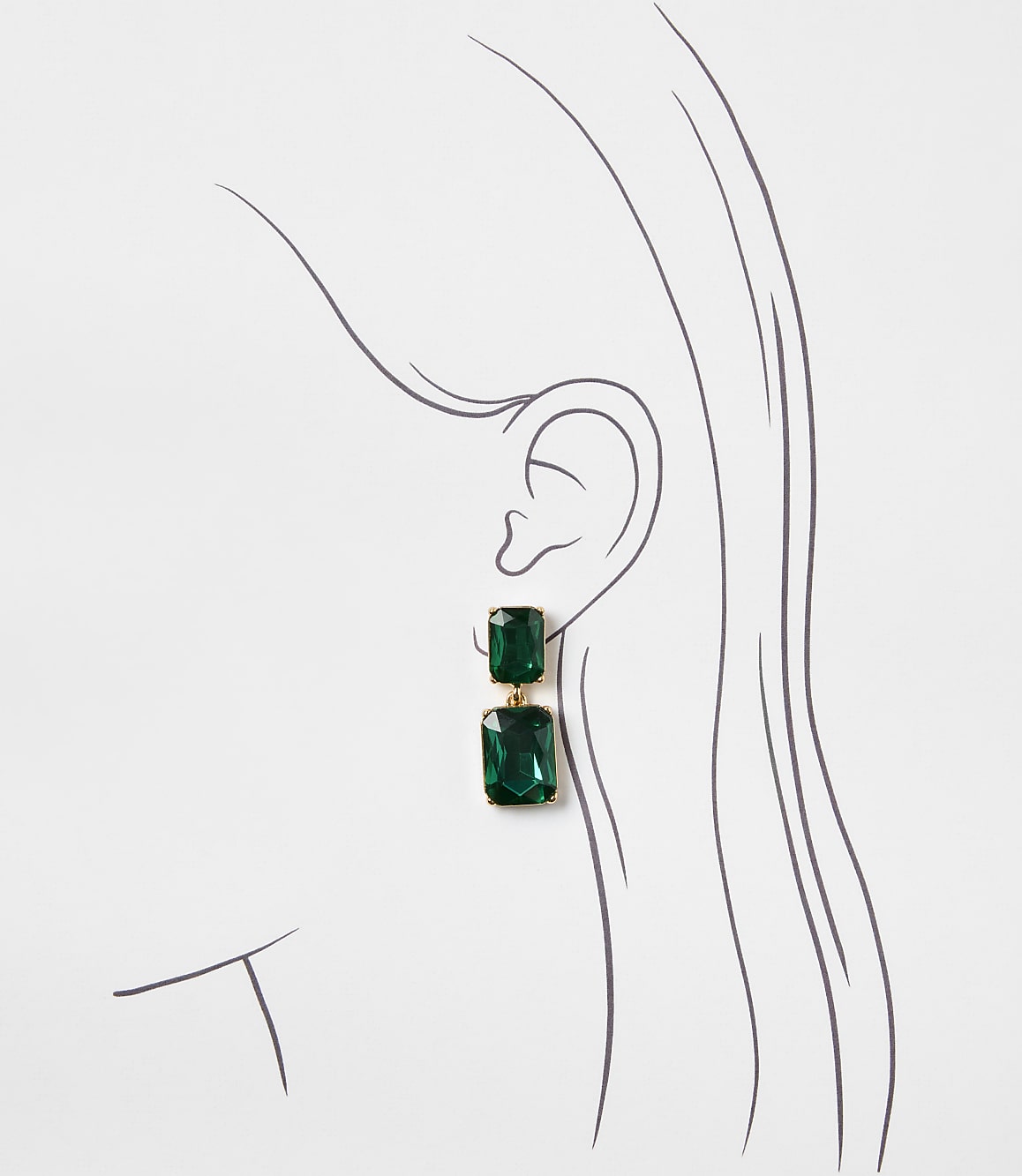 A pair of emerald green drop earrings hangs from the ear of a minimalist line drawing of a woman's profile against a plain white background.