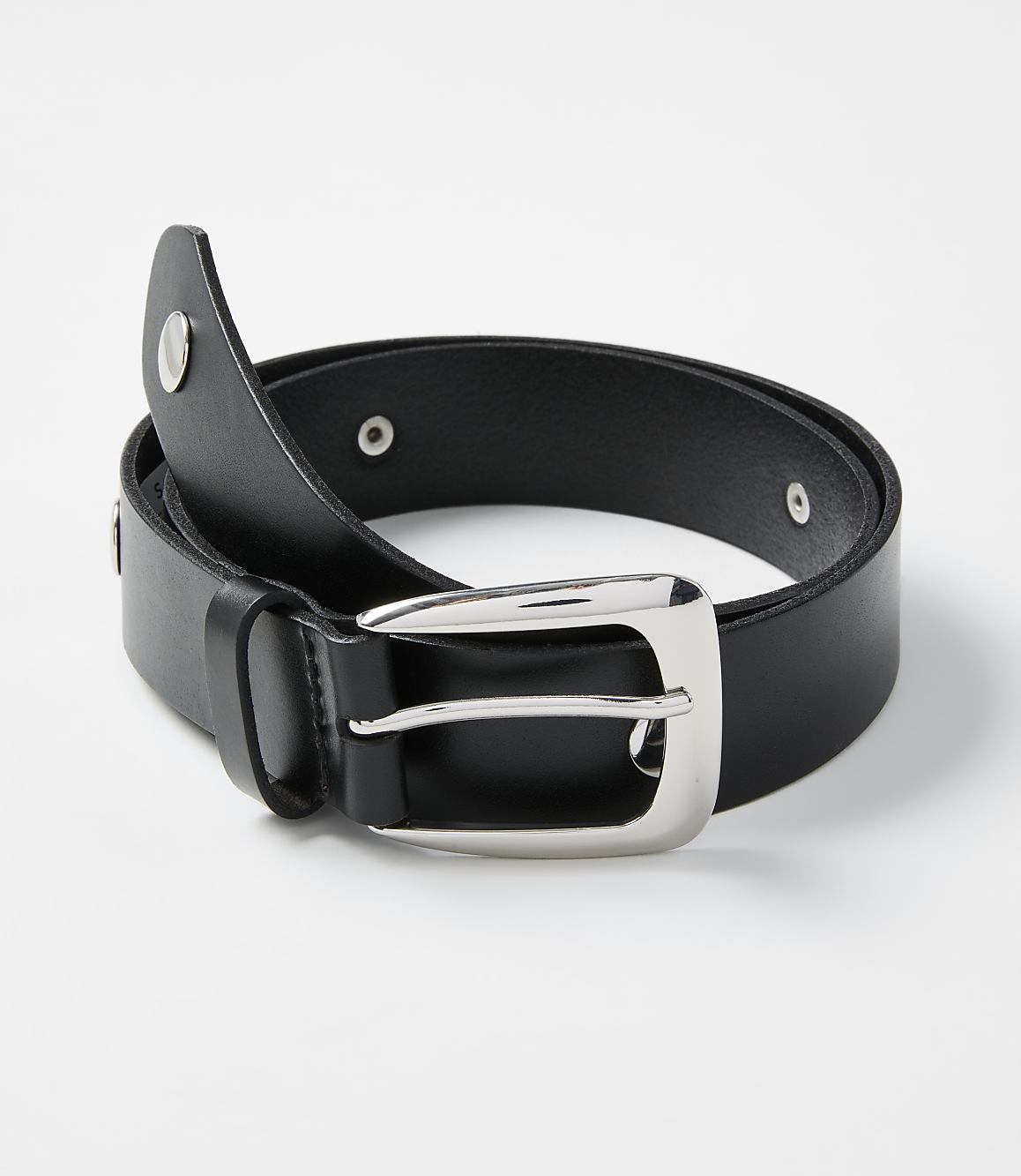 A black leather belt with a silver buckle is coiled on a plain white background.