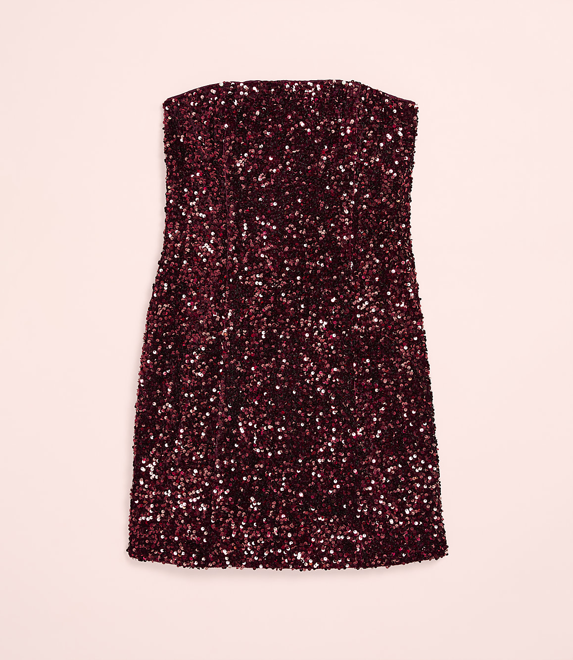 A strapless, burgundy sequined mini dress is centered against a solid light pink background.