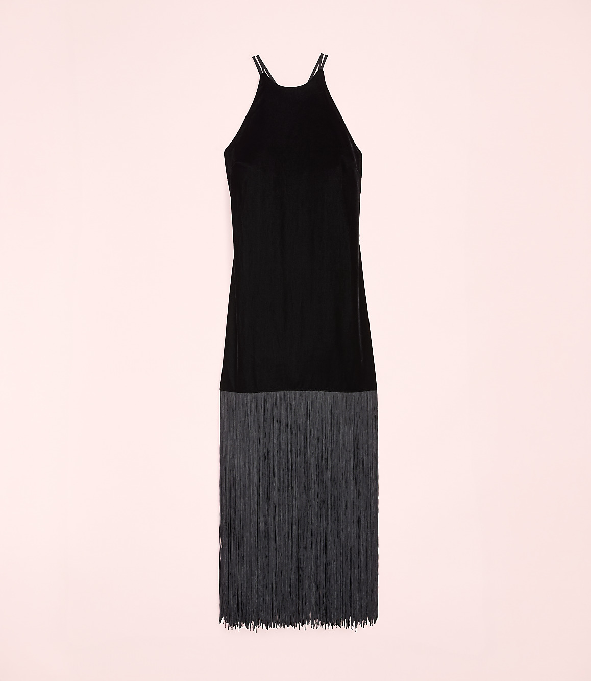 A black sleeveless dress with a fringed hem is centered against a solid light pink background.