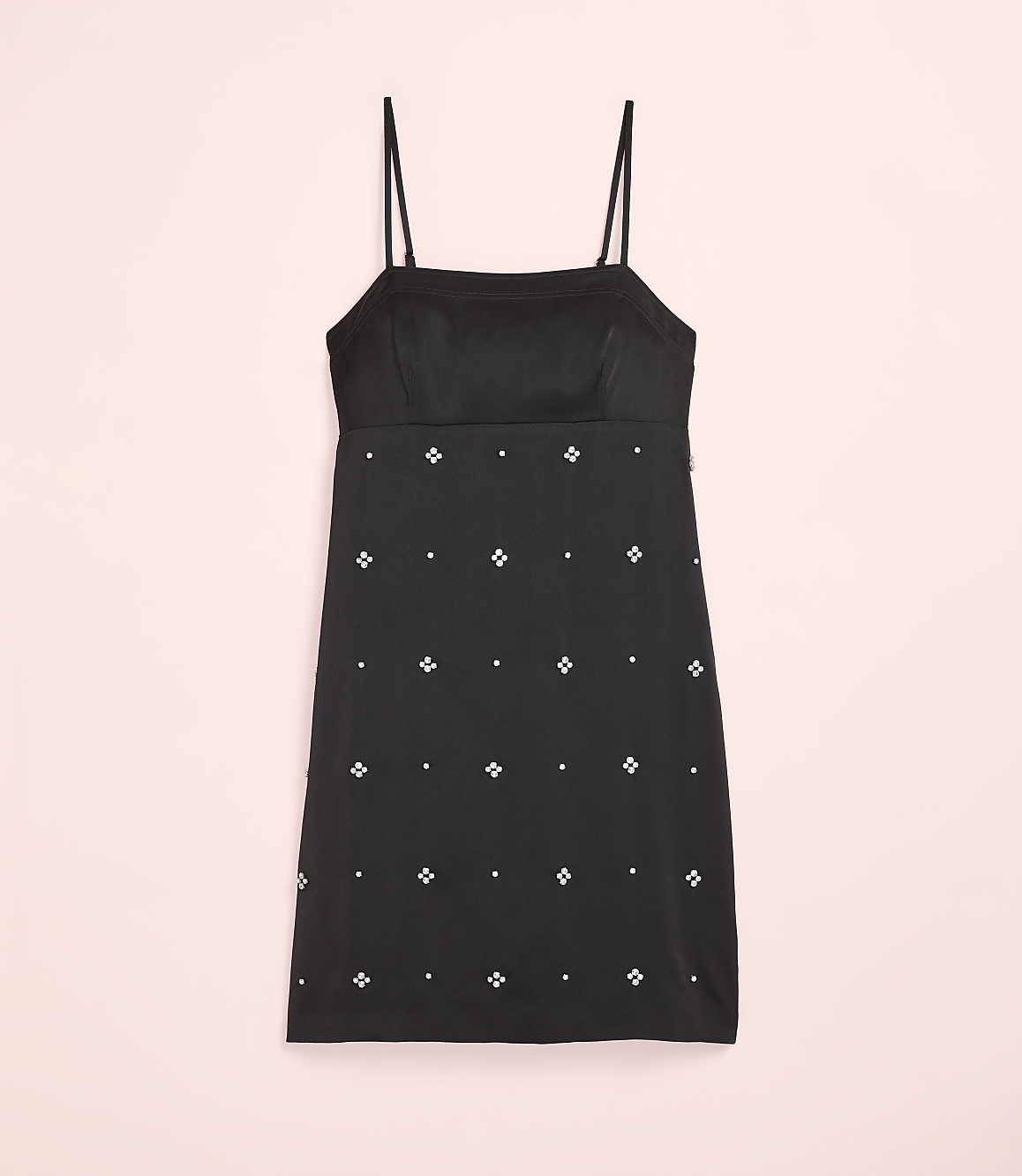 A black mini dress with small white floral embellishments is centered against a plain light pink background.