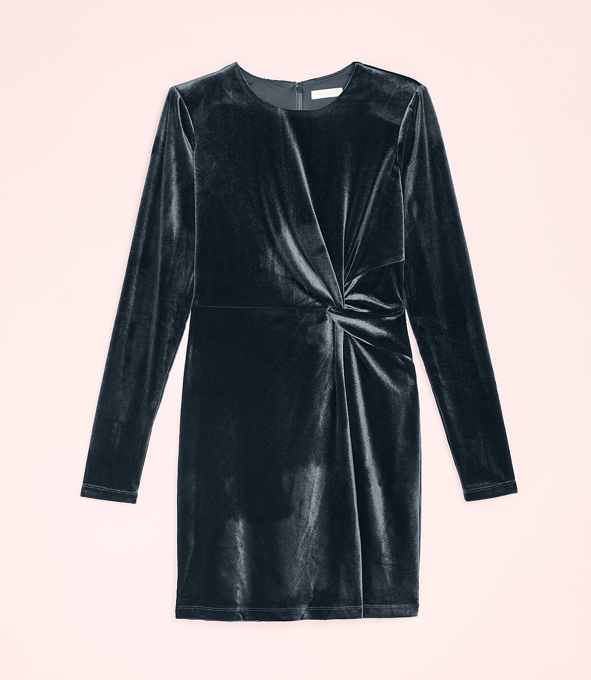 A dark navy velvet long-sleeved dress with a twisted waist detail is centered against a pale pink background.