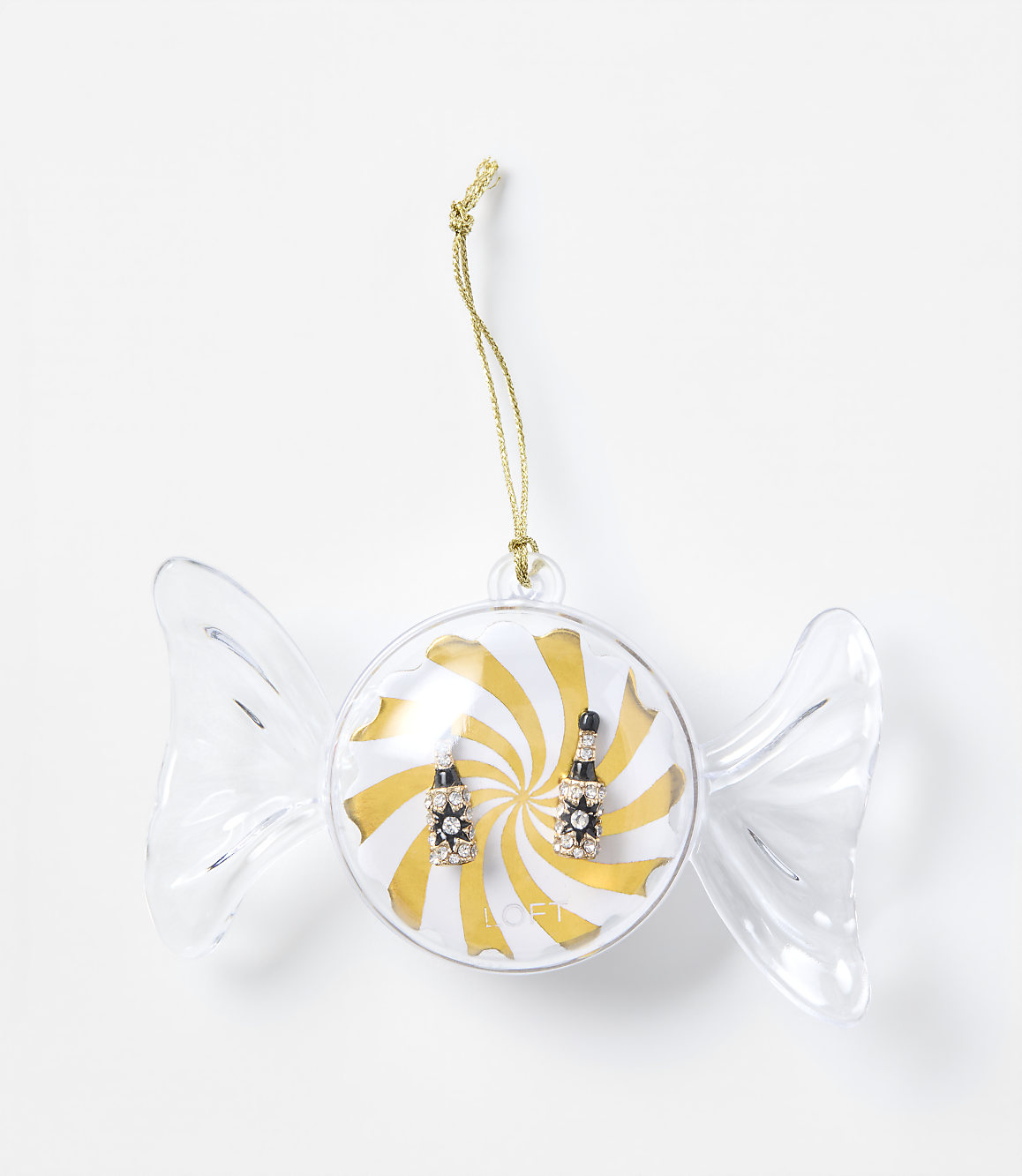 A pair of sparkling earrings sits inside a candy-shaped clear ornament against a plain white background.