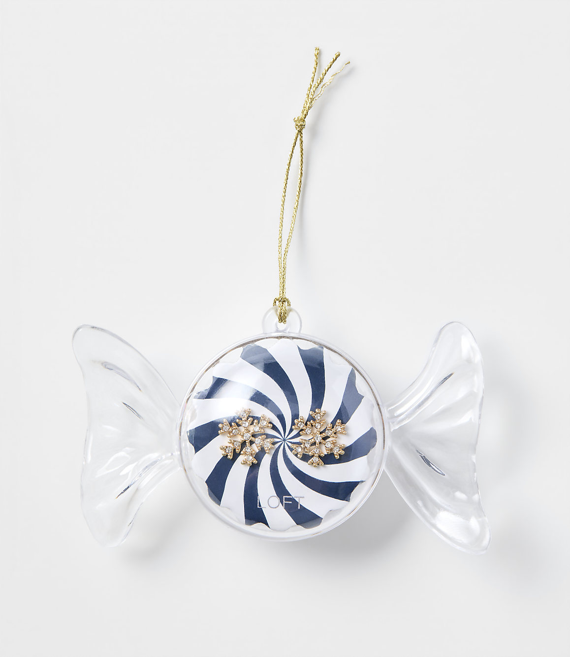 A candy-shaped Christmas ornament with blue and white stripes and gold snowflakes hangs by a gold string against a plain white background.